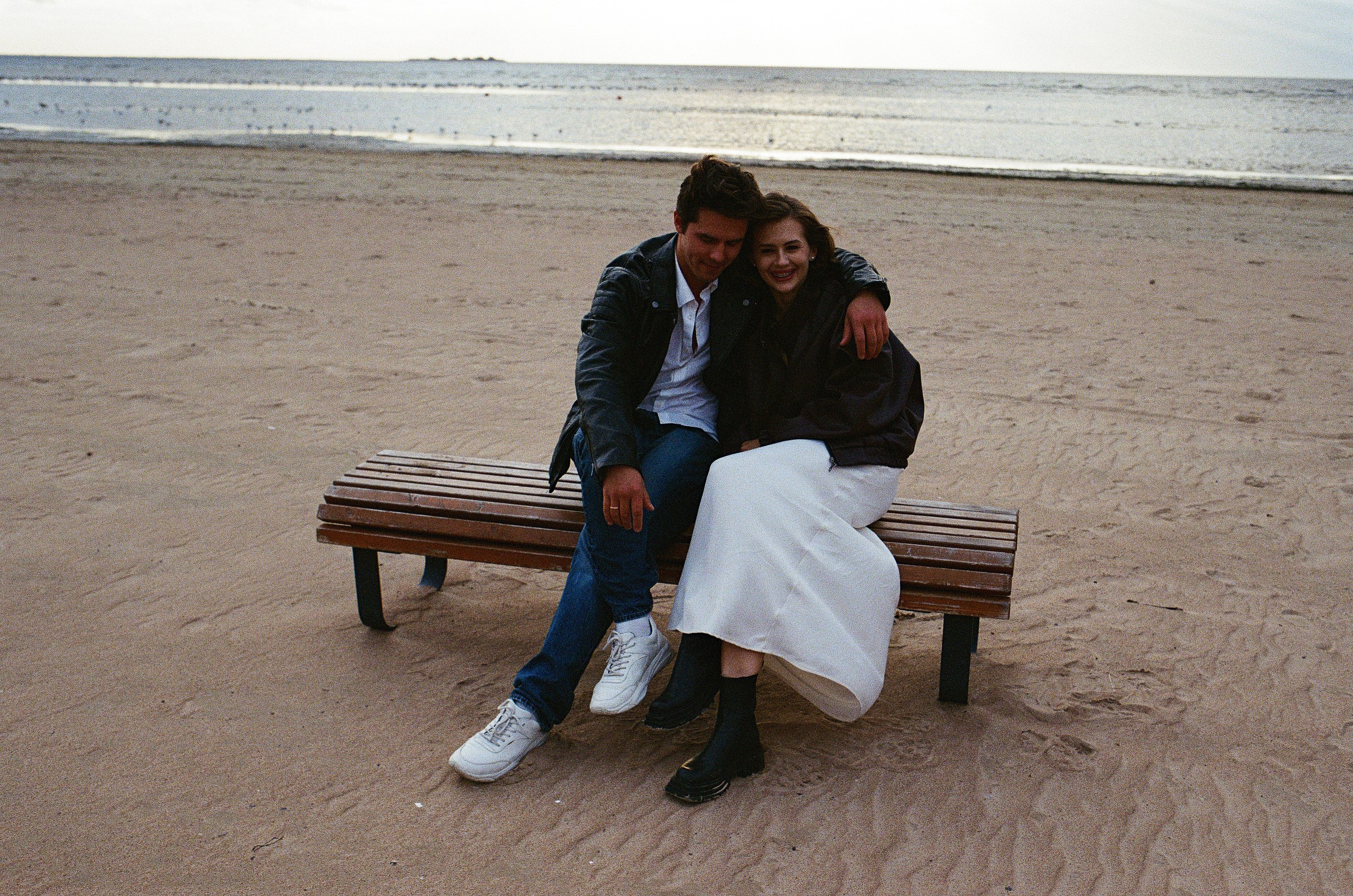 Пара сидит на пляже, вид на Финский залив, романтичная сцена