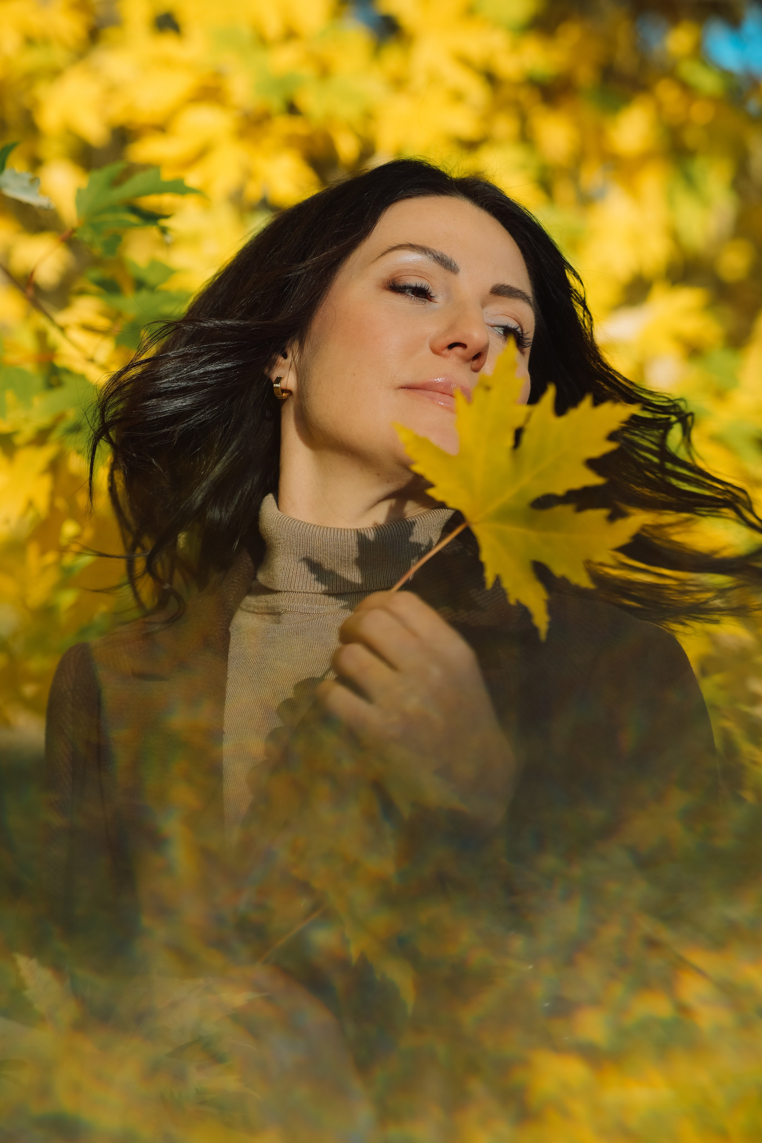 Красивая девушка брюнетка в парке золотой осенью в желтых кленовых листьях