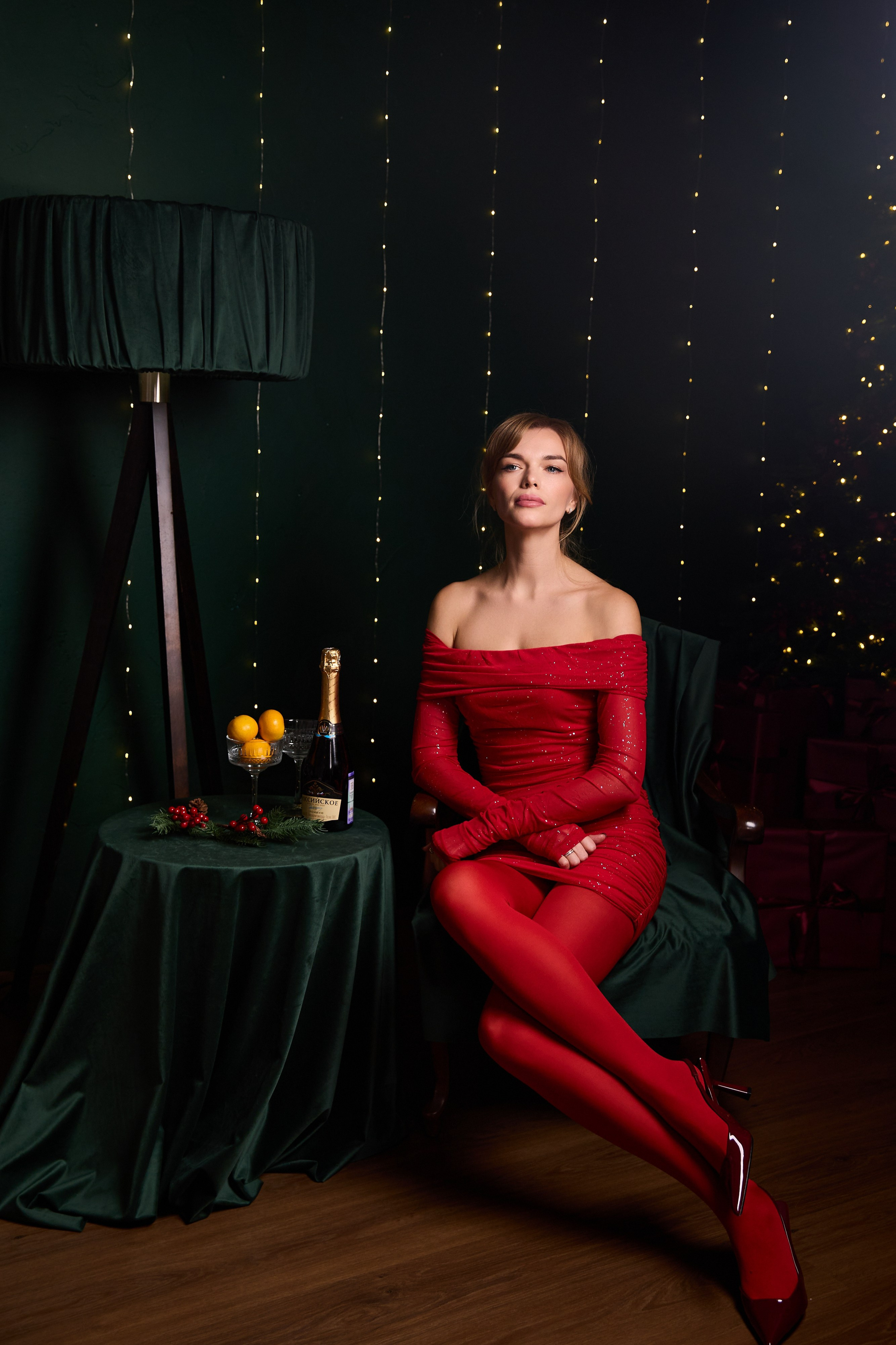 фотосессия портрете девушка в красном платье с открытыми плечами с огоньками на заднем плане