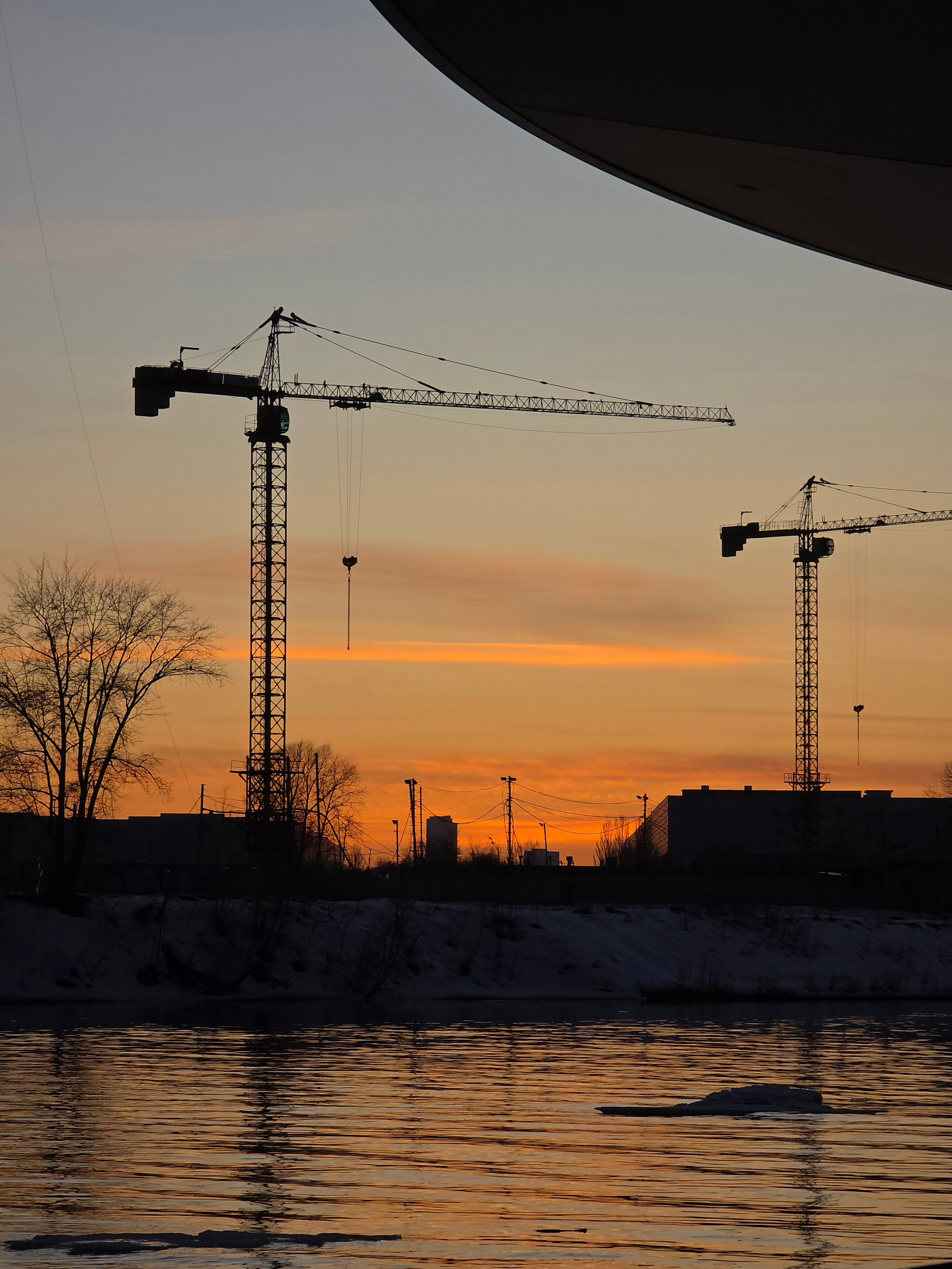 Стройка ведется по обоим берегам реки. Закатные краны