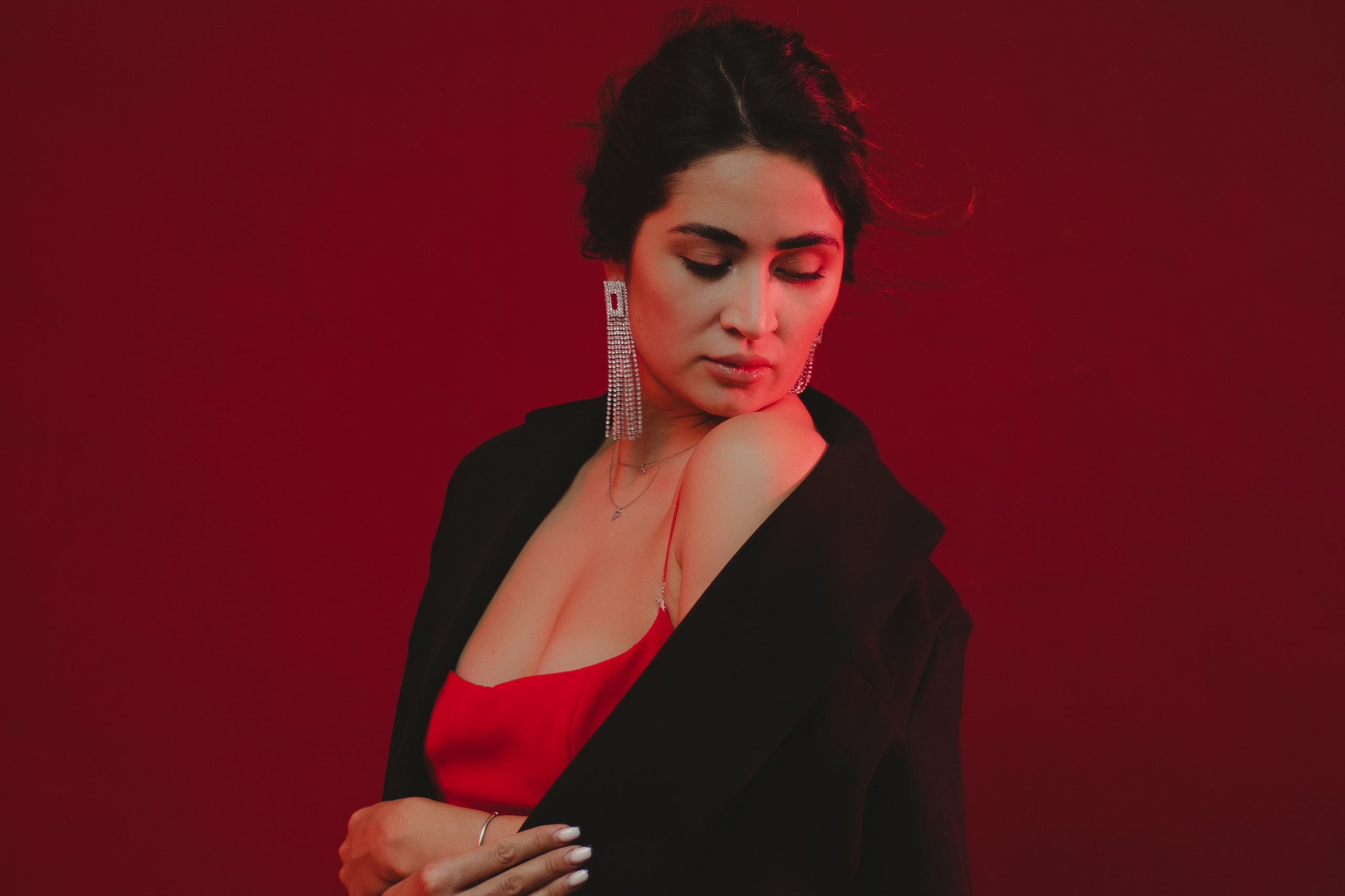 Портрет девушки на красном фоне в красном платье и черном жакете