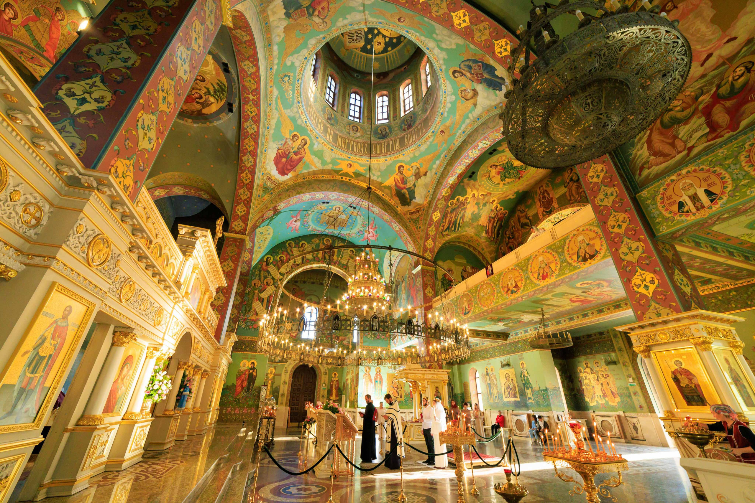 Таинство венчания на фоне старинных икон и церковной росписи.