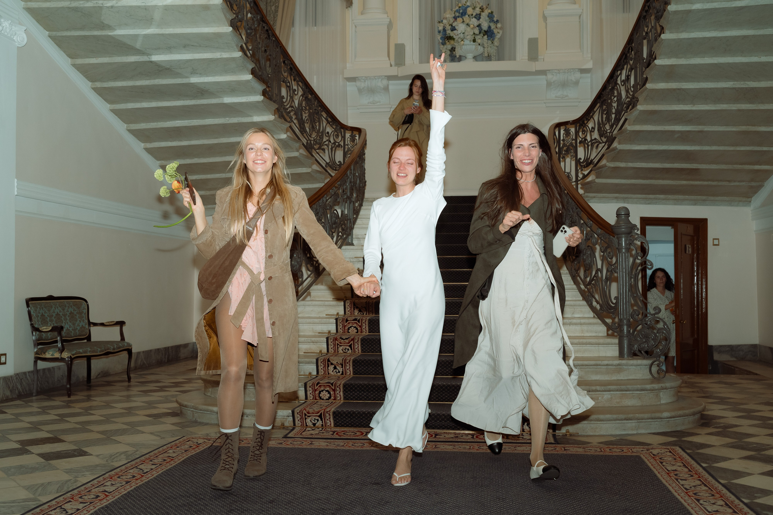 Мария с букетом и две подруги радостно сбегают по мраморной лестнице парадного зала