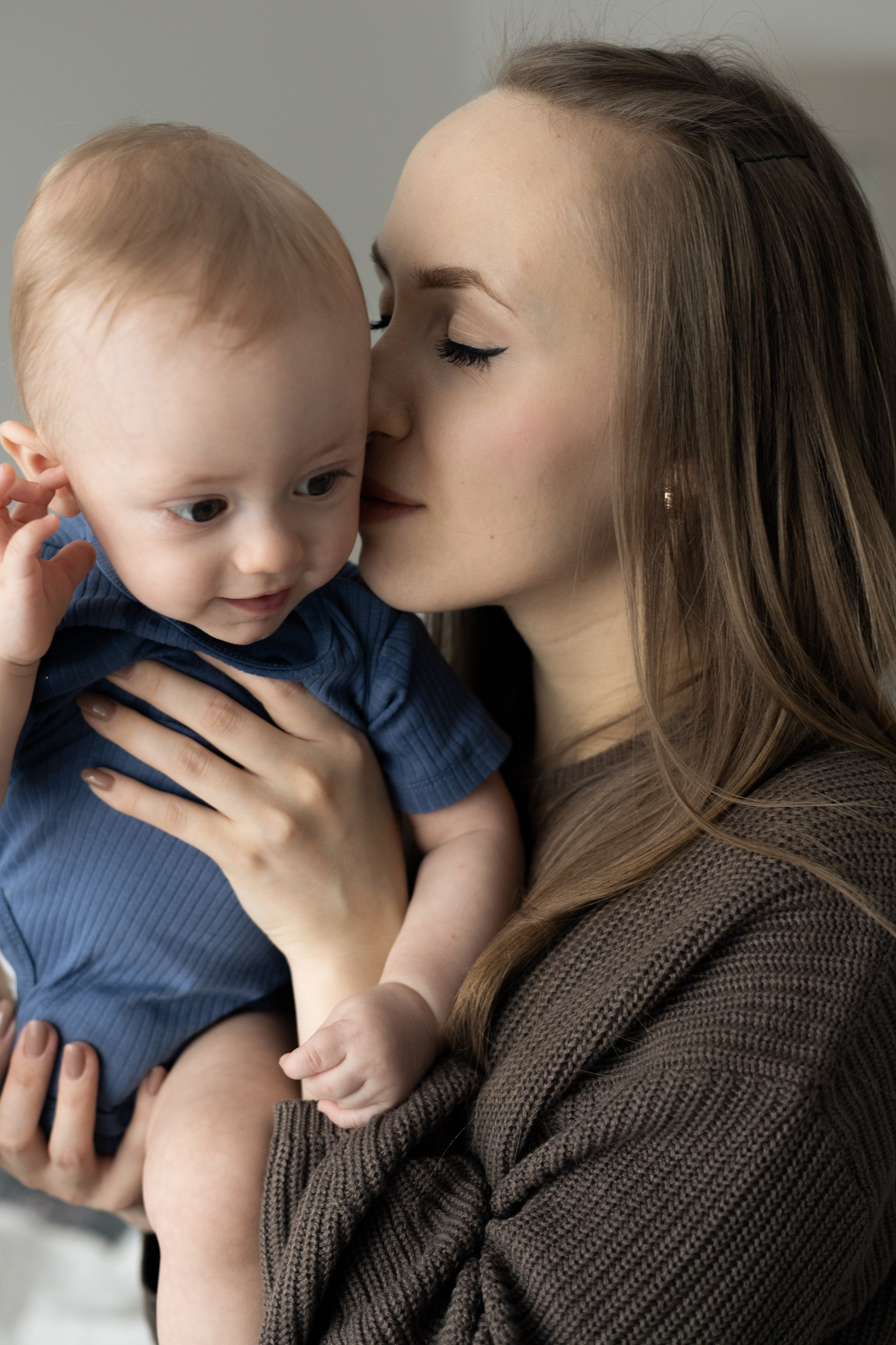 Мама держит сына на руках и целует