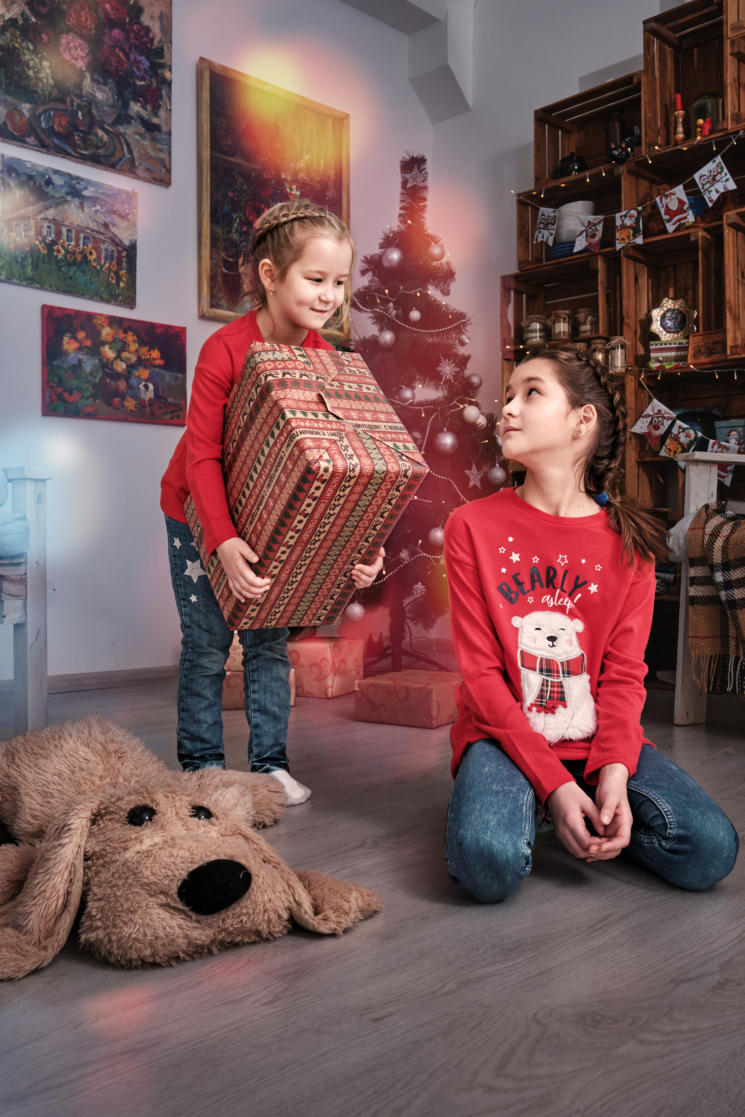 Две сестры у новогодней ёлки с подарками