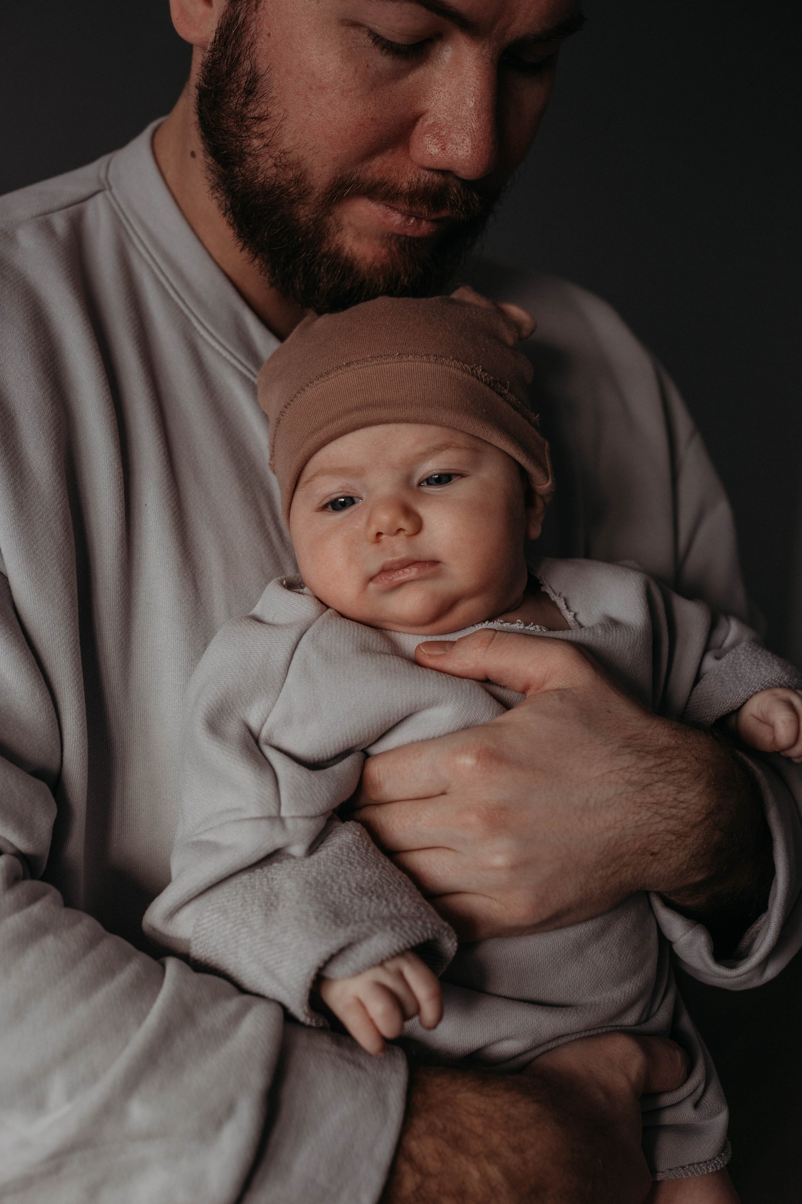 папа держит маленького ребенка на руках дома