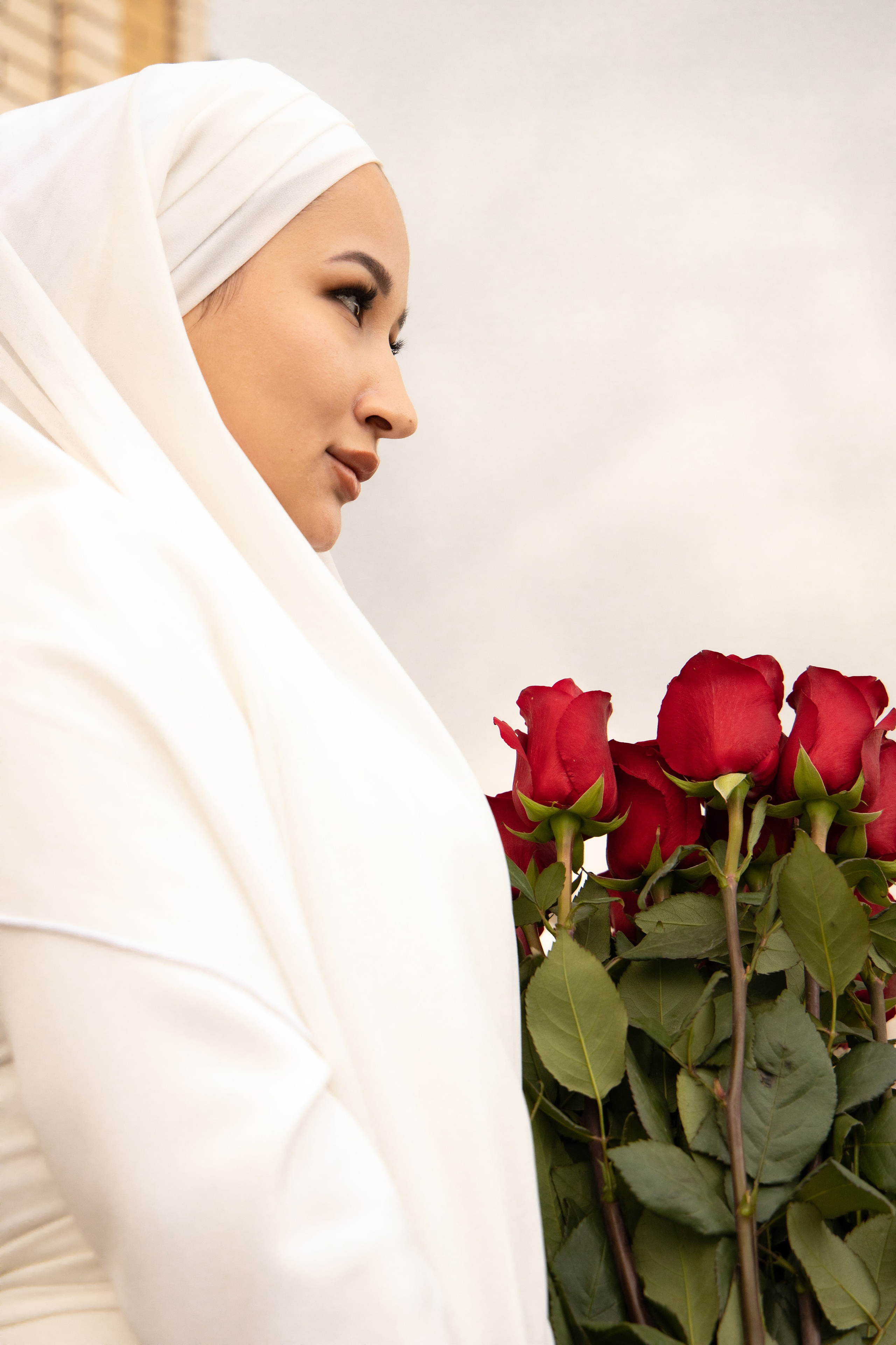 Невеста, мусульманка, в профиль с букетом красных роз. Свадебная фотосессия Астрахань.