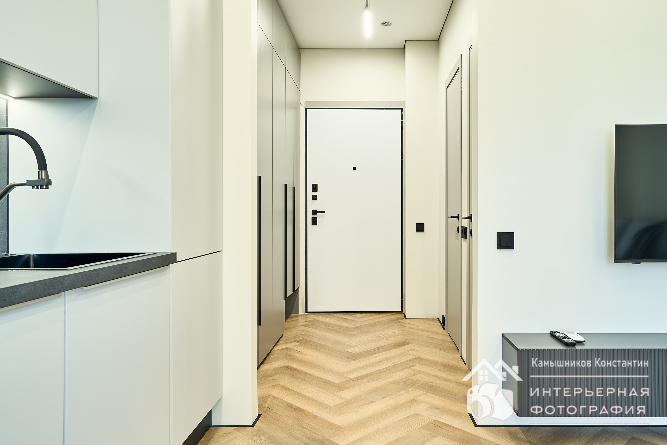 Интерьерное фото входной двери, средний план, ракурс - фронтальный, от окна в гостиной в апартах в ЖК Метрополия от MR Group