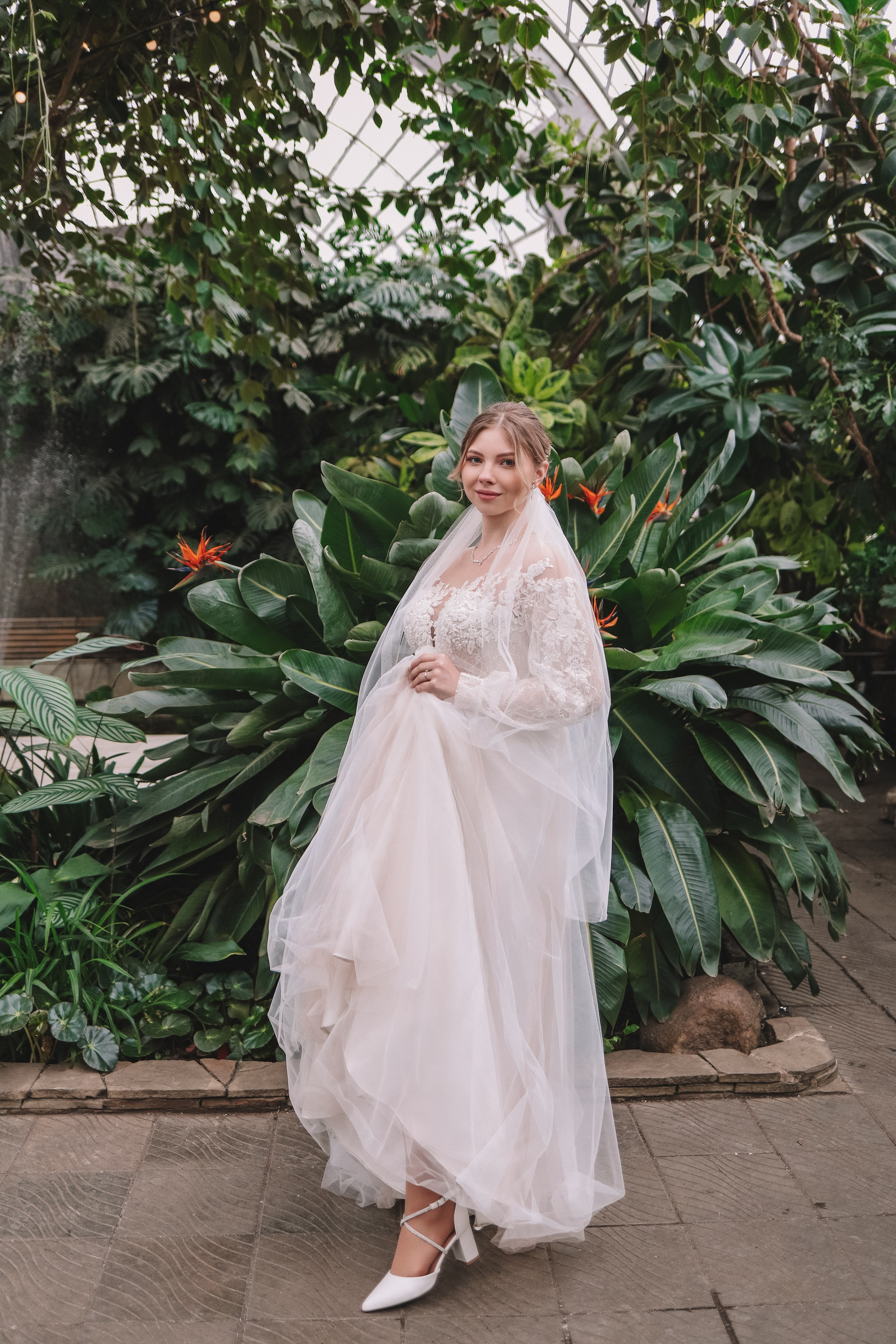 Невеста в полный рост в оранжерее, лёгкое платье