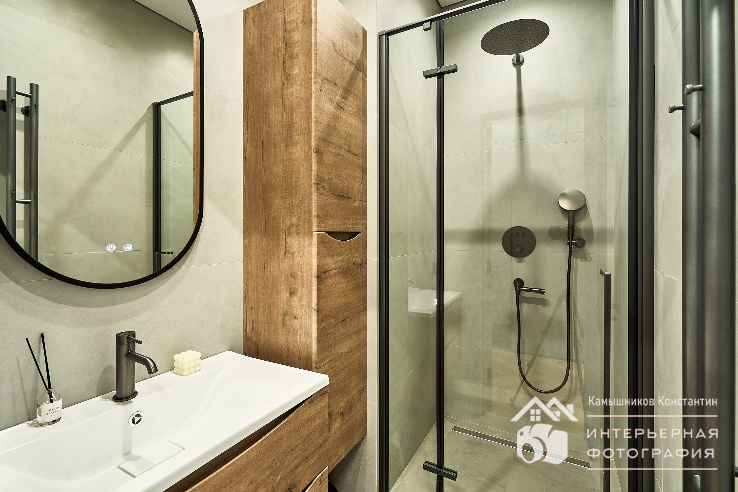 Интерьерное фото санузла, диагональный общий план с раковиной, зеркалом и душевой кабиной