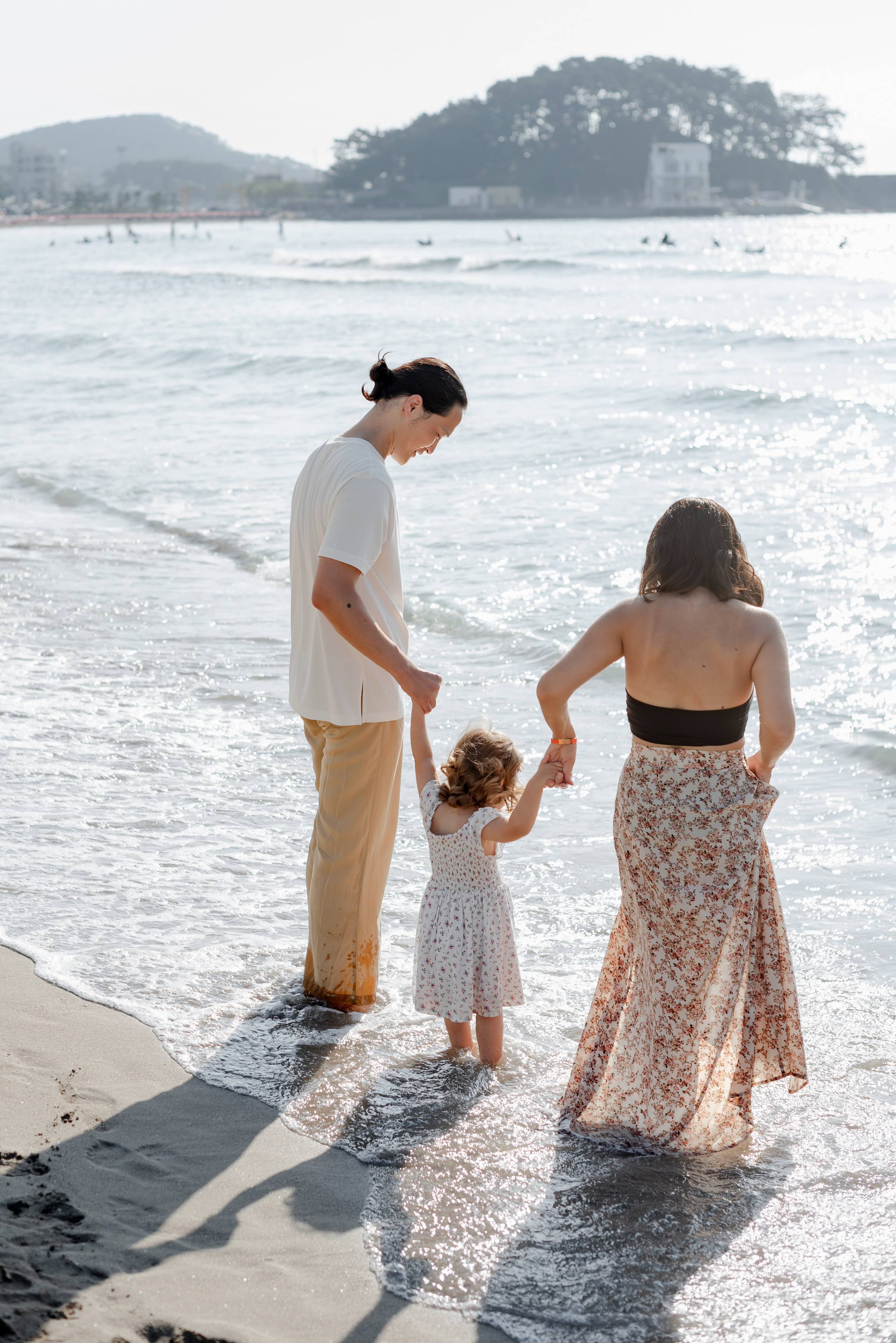 Family with a child walking along the beach in Busan — photoshoot for travelers · 부산 여행 스냅