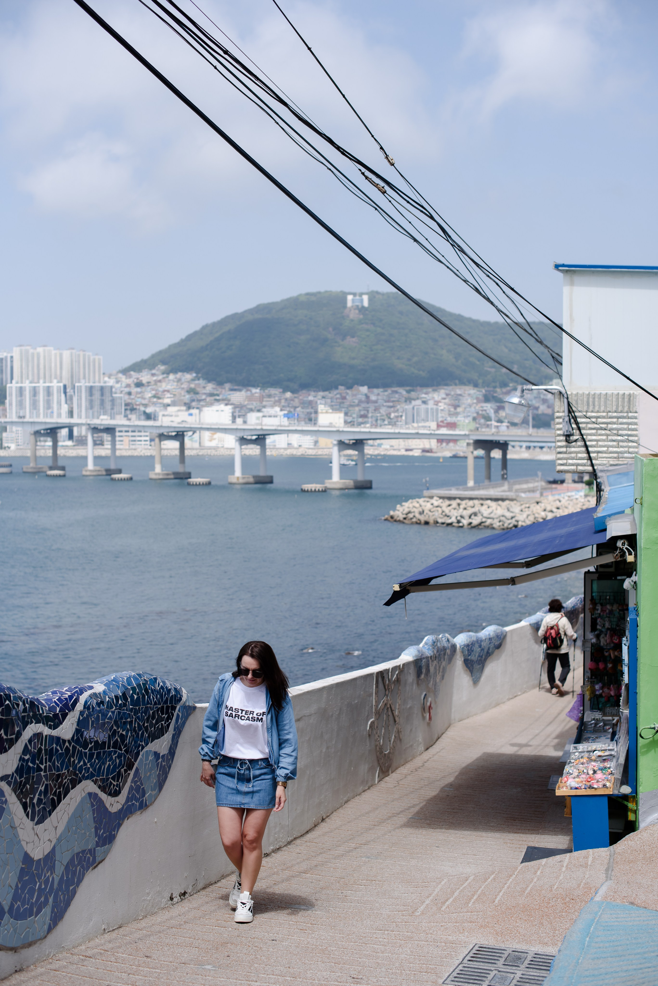 Woman on the Huinnyeoul coastal path with a view of the sea and bridge, Busan · 釜山旅遊攝影