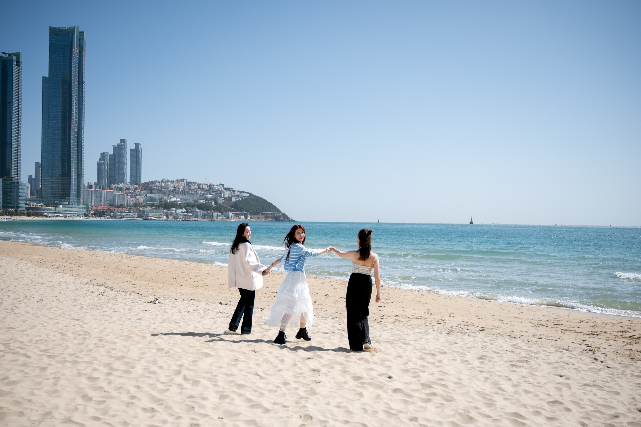 Friends on Haeundae Beach with a view of the Marine City skyscrapers, Busan · 釜山旅遊攝影