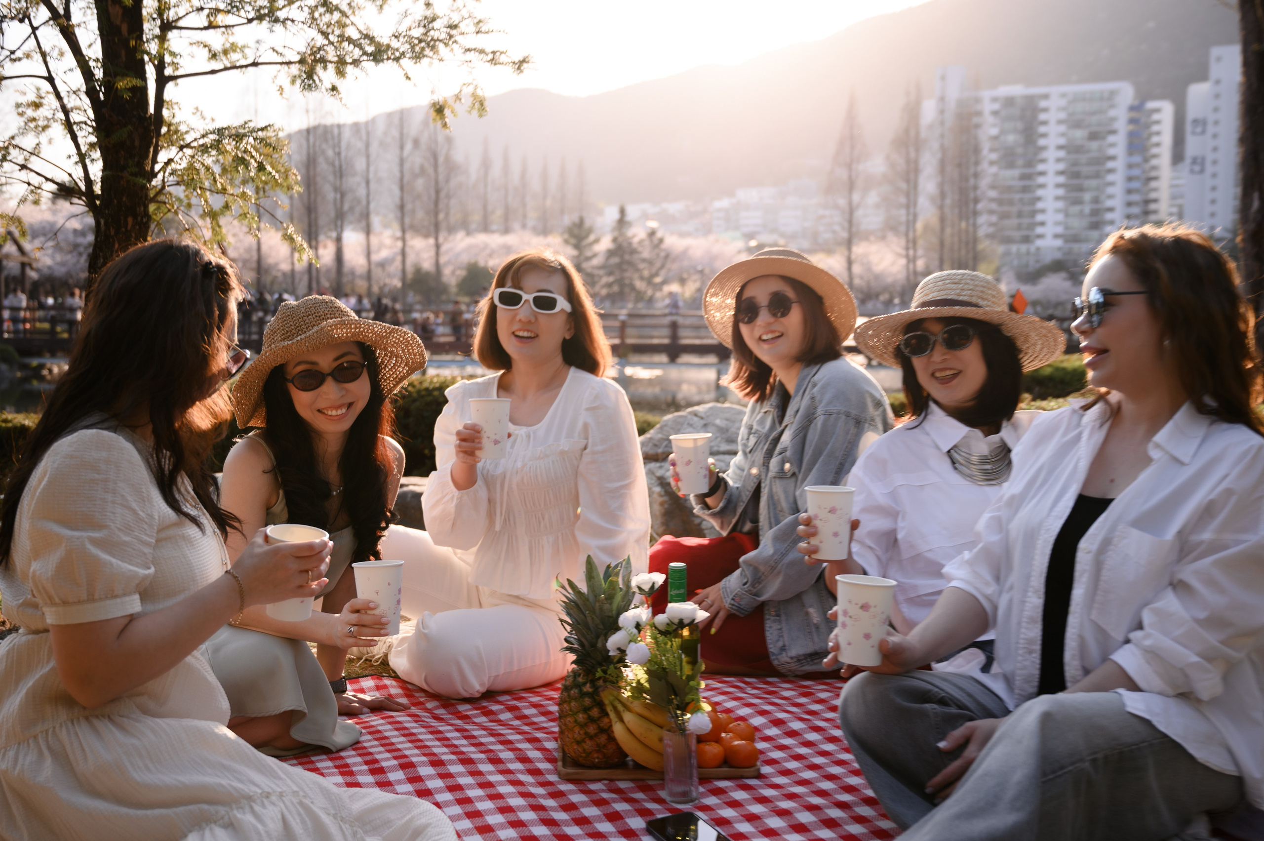 Friends at a sunset picnic with a view of the Haeundae skyline, Busan · 釜山旅拍