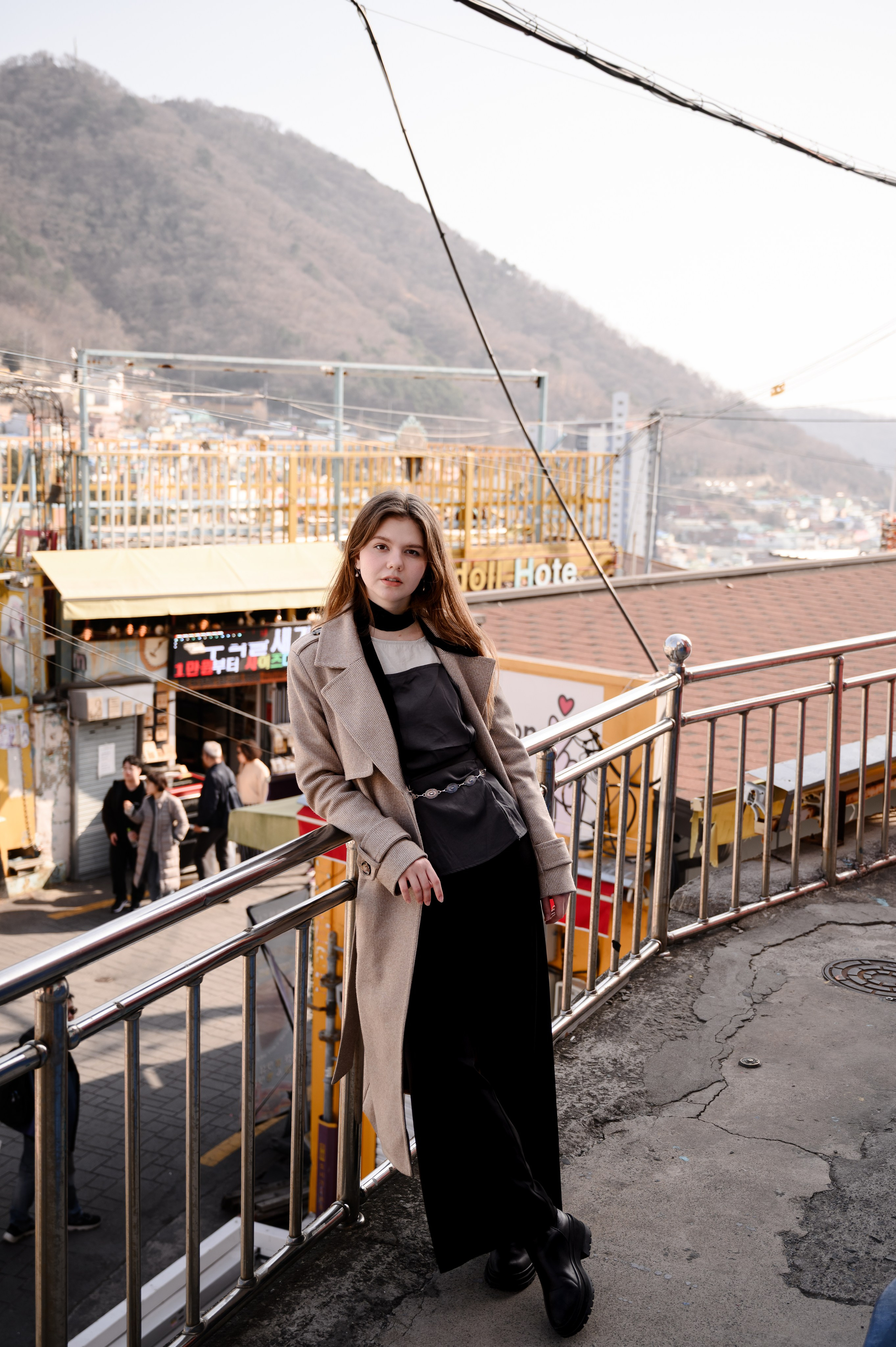 Woman in a long coat at a seaside viewpoint in Busan — travel photoshoot · 釜山 旅行フォト