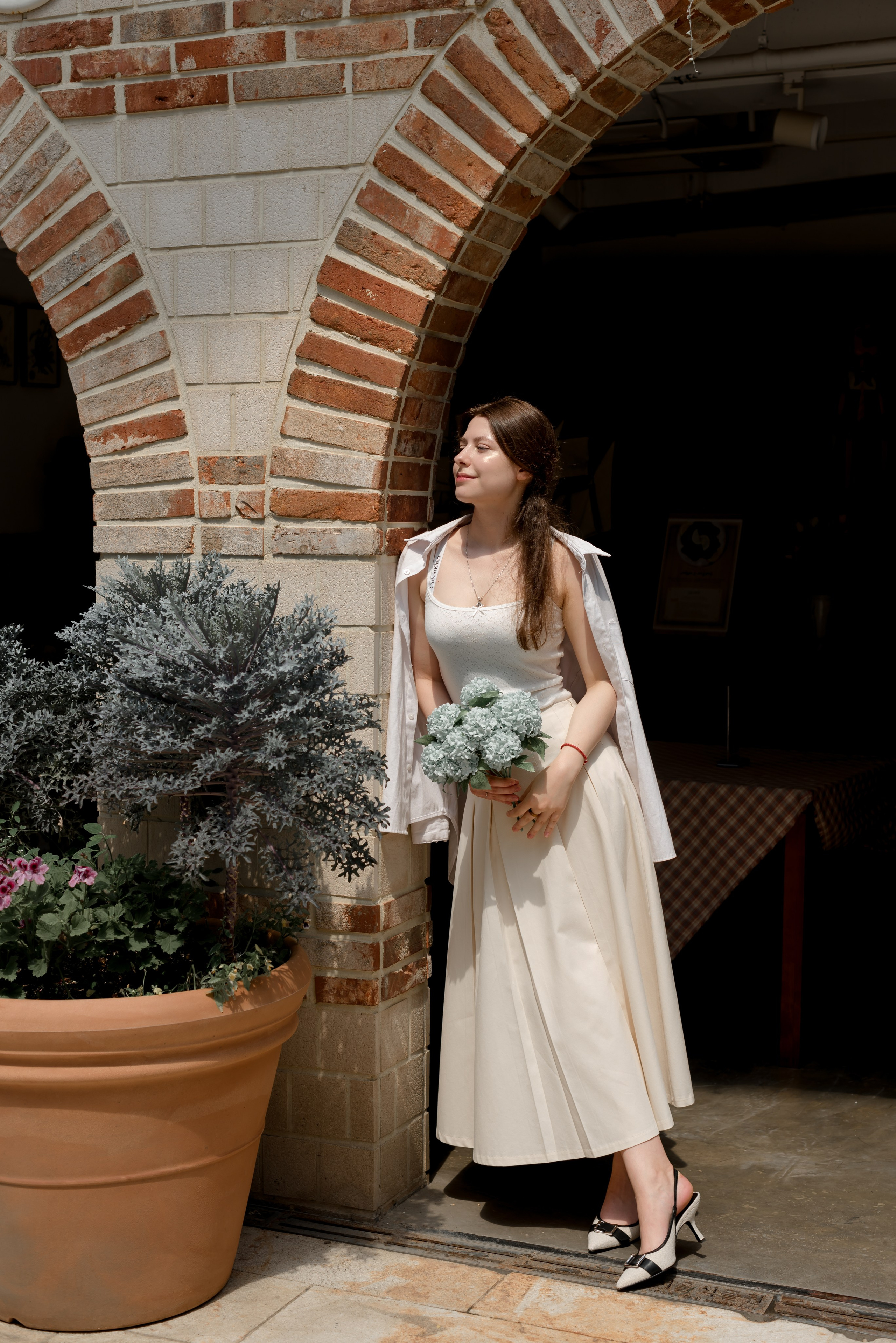 Woman with a bouquet by a brick arch in Busan — travel photoshoot · 釜山旅遊攝影