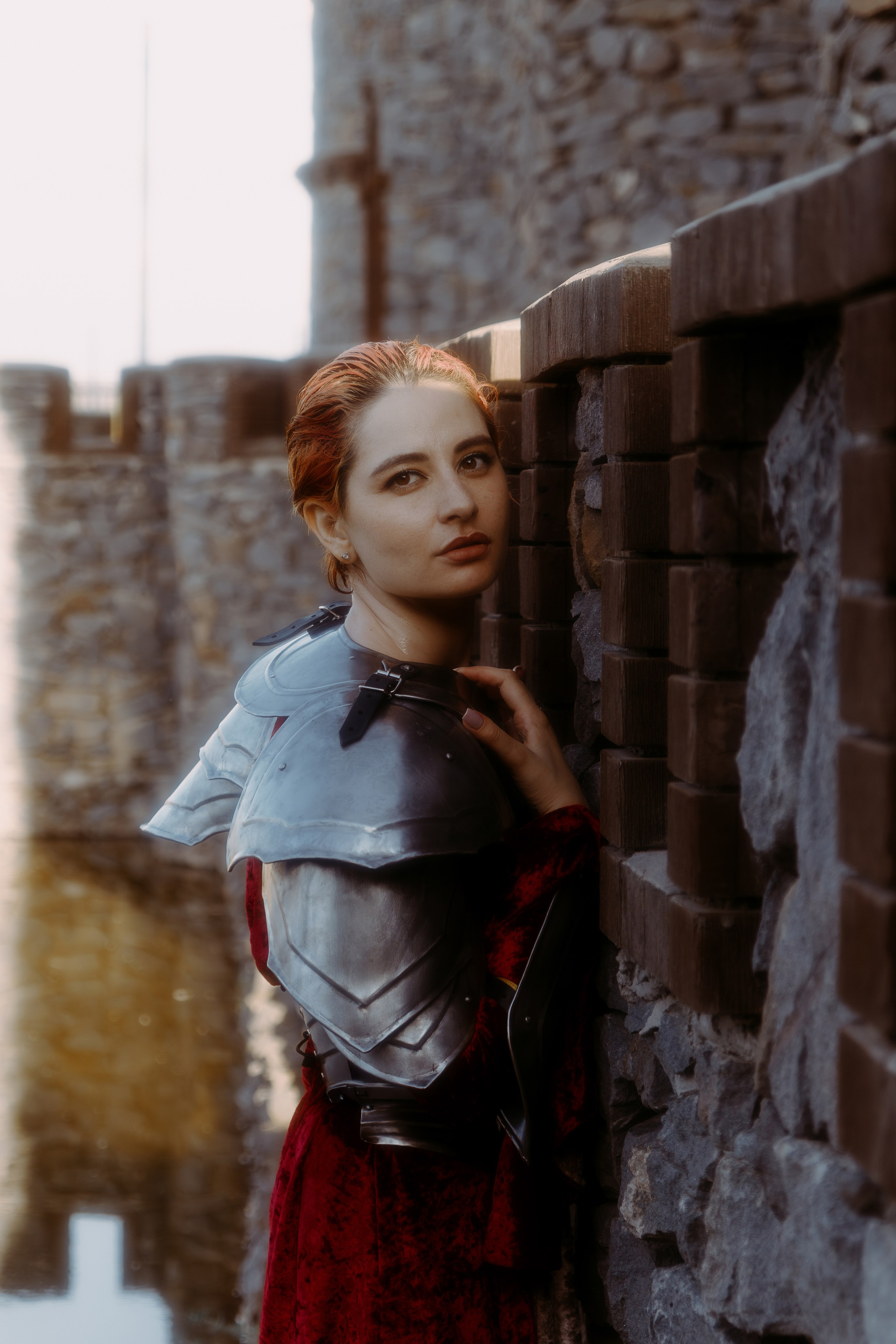 грустная девушка рыцарь перебирается по воде, рядом с рыцарским замком