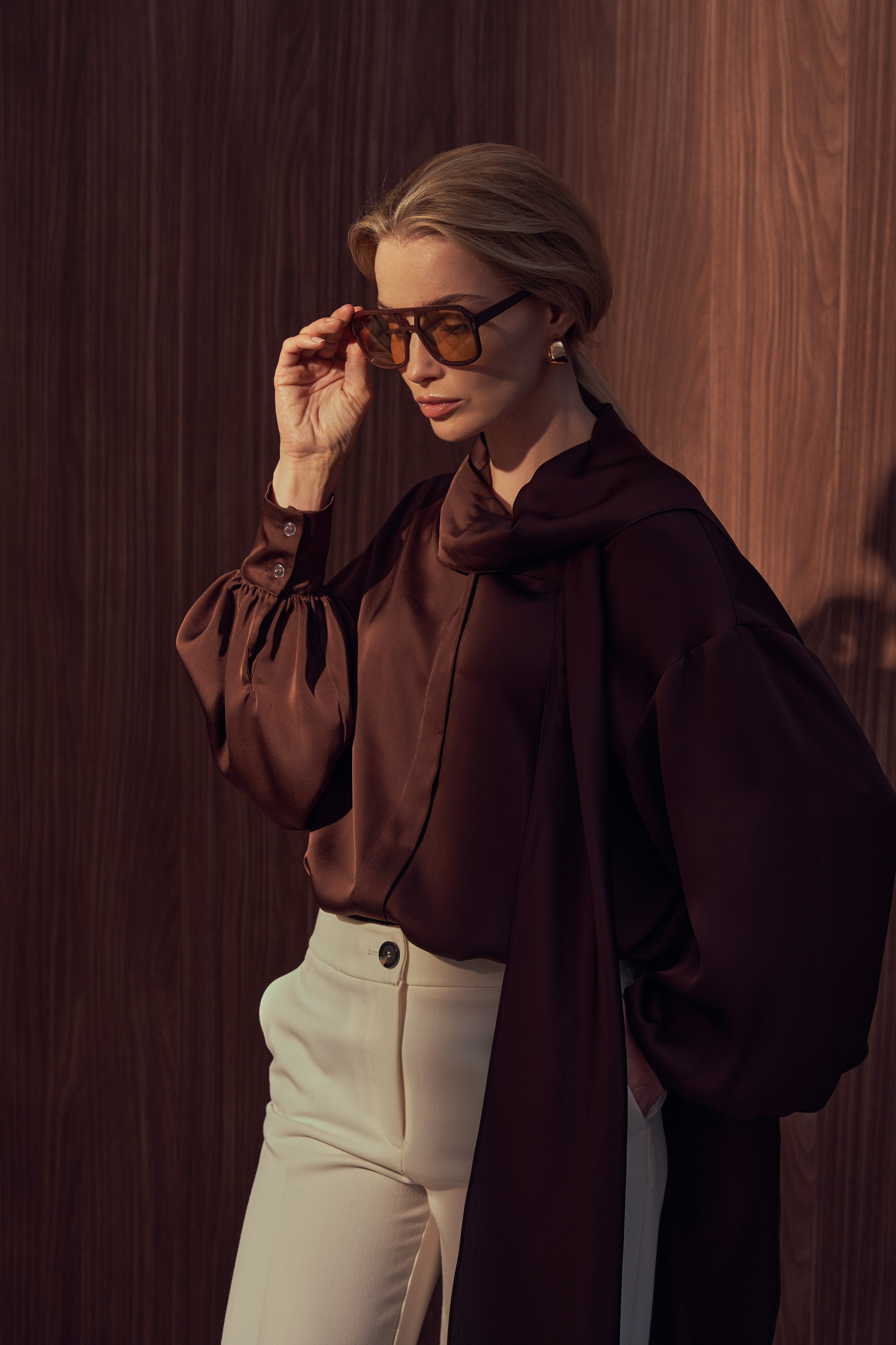 Съемка лукбука в стиле ретро, девушка блондинка в блузе с бантом в белых брюках, в очках