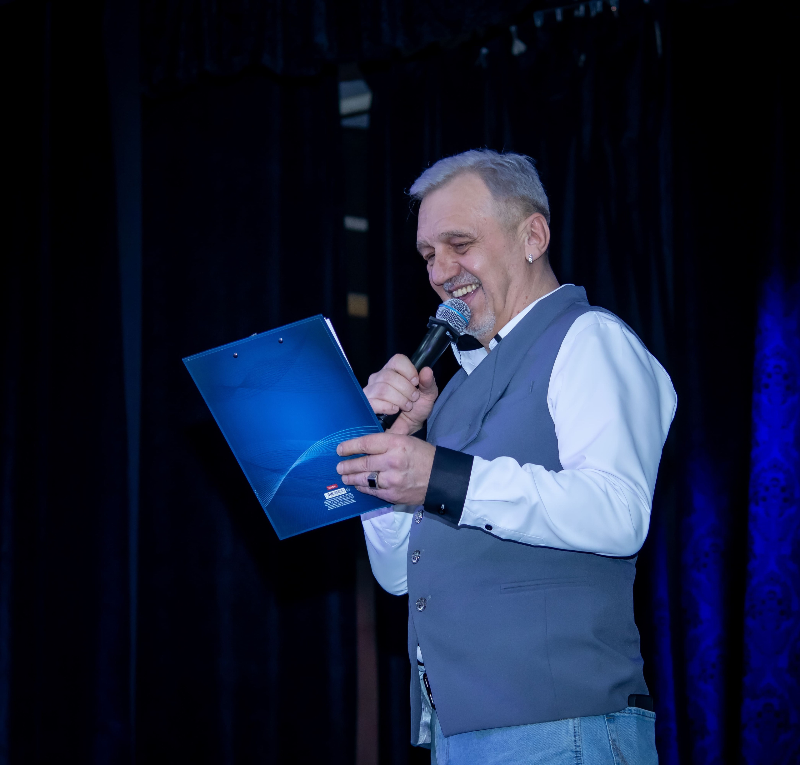 Ведущий Анатолий Воронов с микрофоном на юбилее Радио «Птица», концерт в Москве — фотограф Карасёва Елена