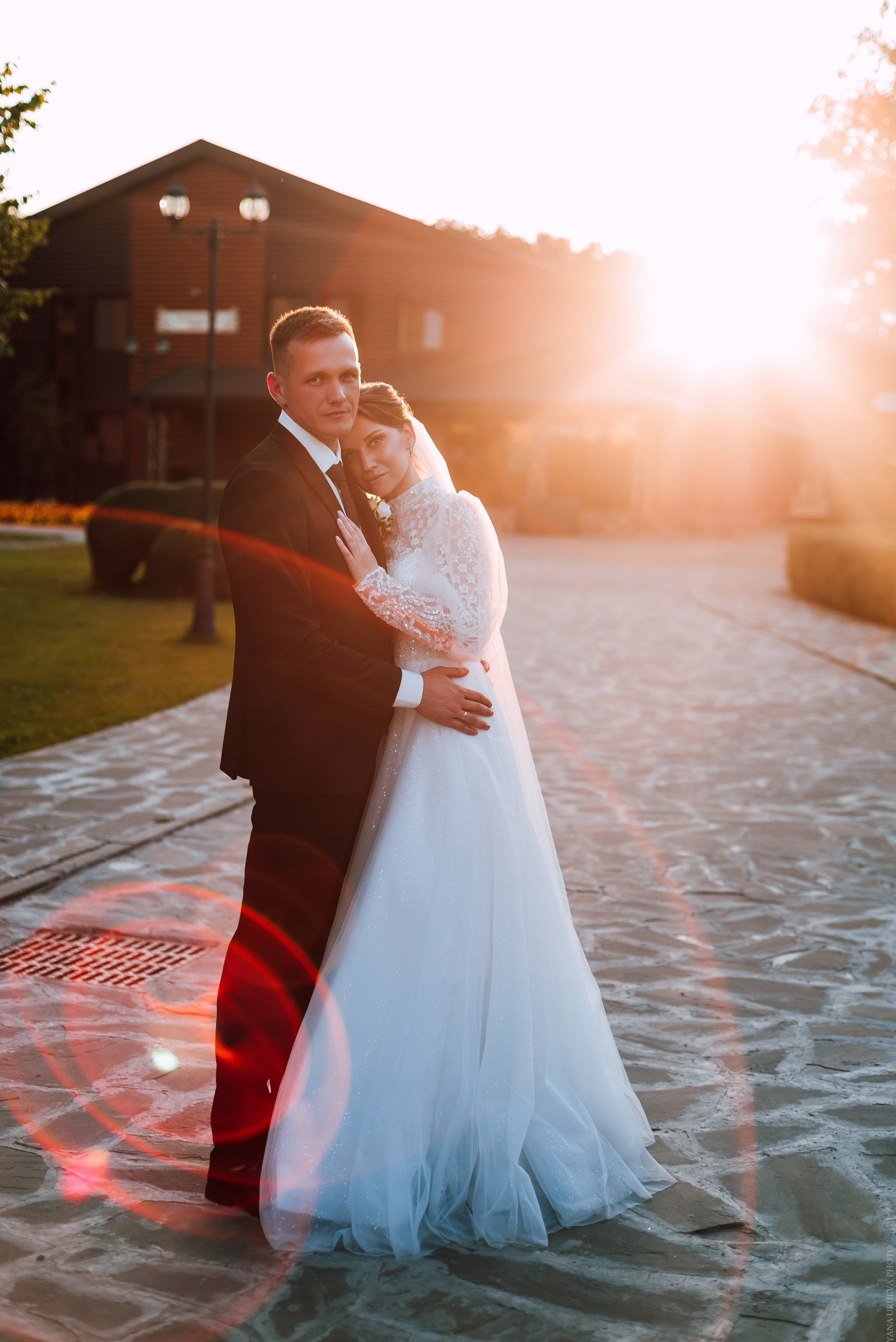 Жених и невеста обнимаются на фоне заката