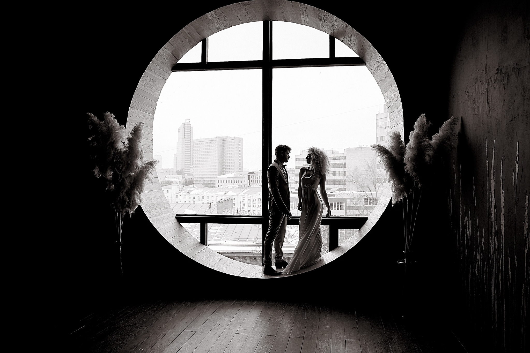 силует невесты и жениха на фоне большого круглого окна  Утро жениха и невесты. Свадебный фотограф Сергей Гаварос. Москва +792566963199ы. Свадебный фотограф Сергей Гаварос. Москва +792566963199