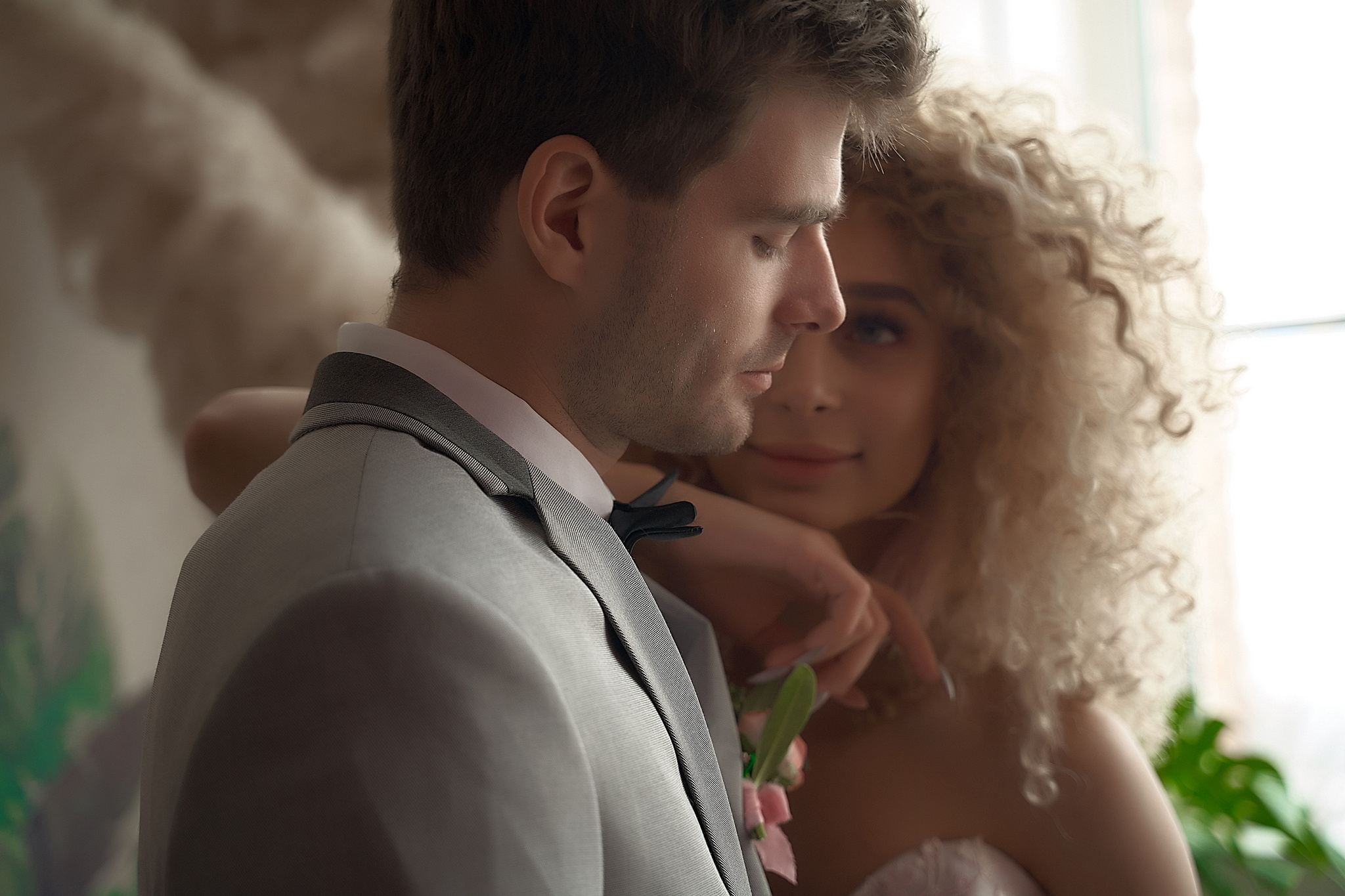 Невеста смотрит на жениха оперевшись на его плечо. Утро жениха и невесты. Свадебный фотограф Сергей Гаварос. Москва +792566963199
