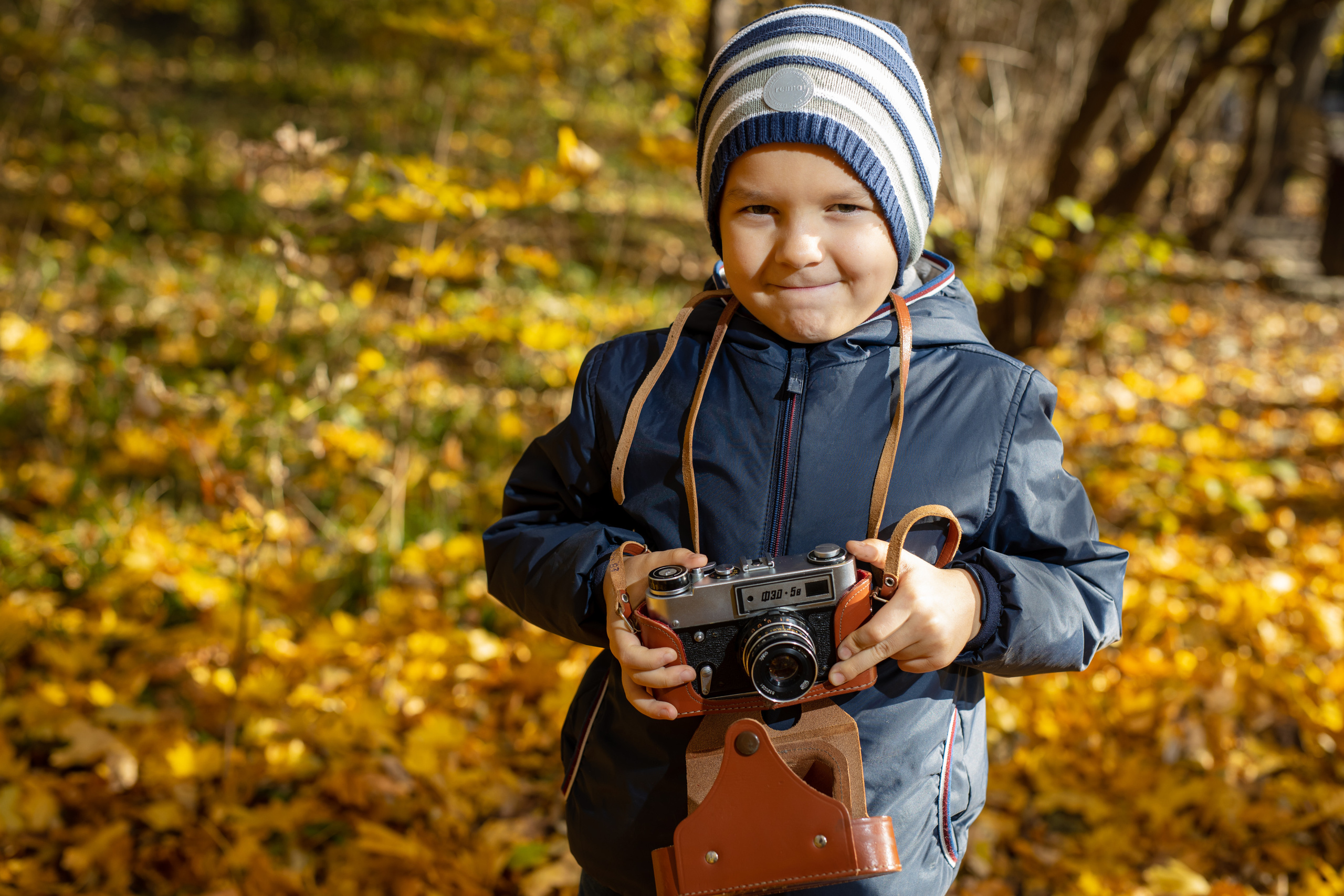 Картинка осень для детей мальчик в осеннем парке с фотоаппаратом