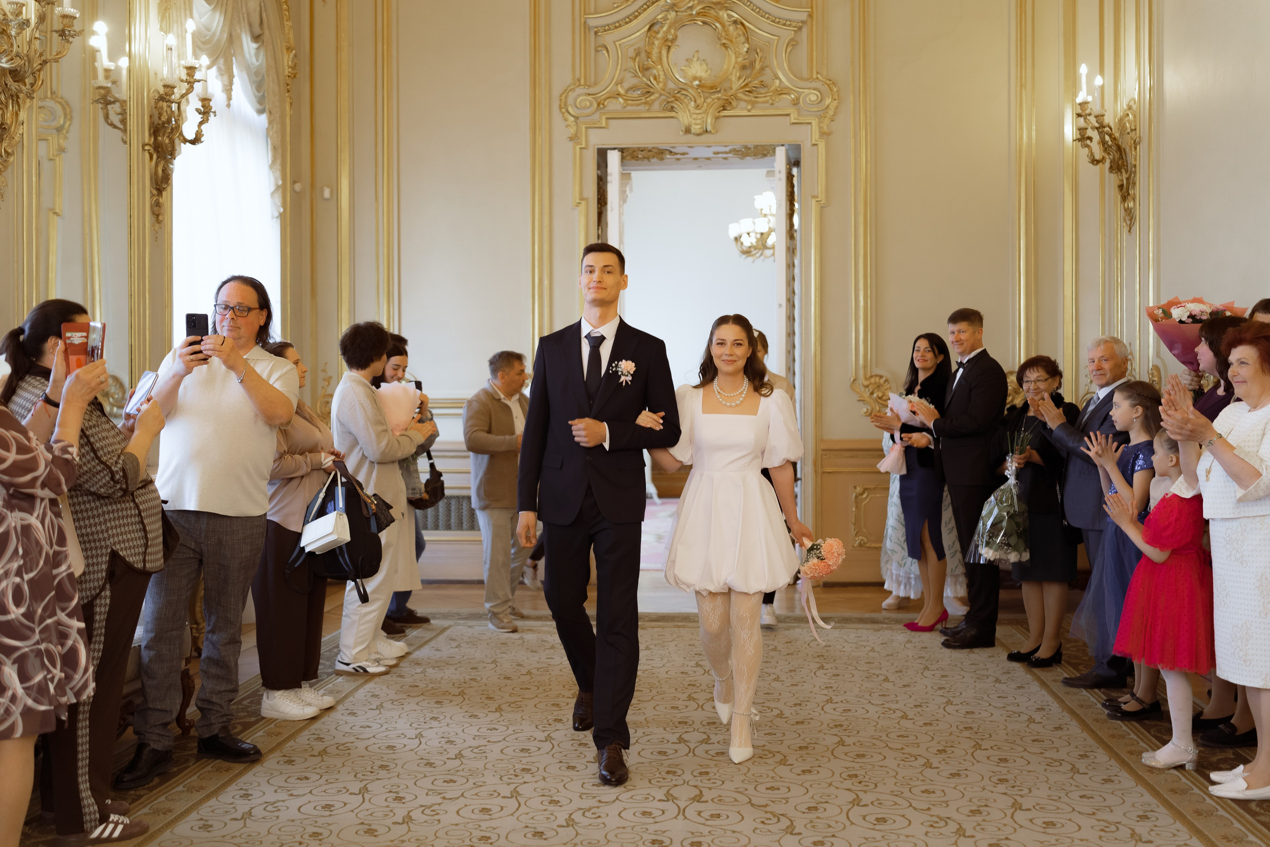 Молодожёны идут к месту регистрации в торжественном зале дворца