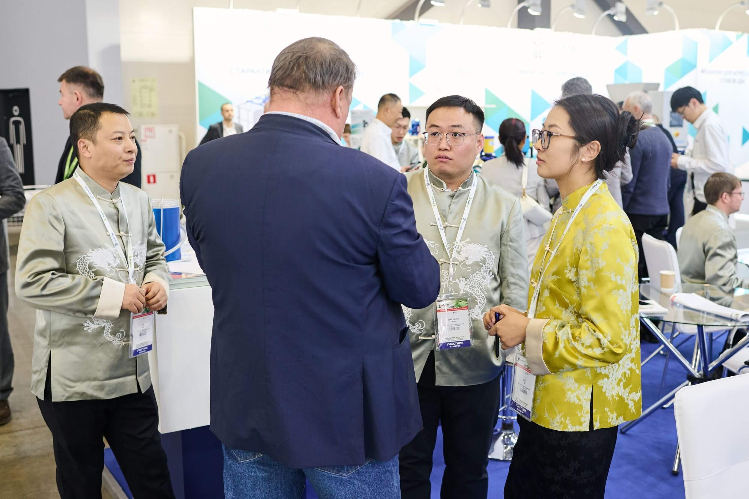 Посетитель общаются с представителем китайской компании на выставке.