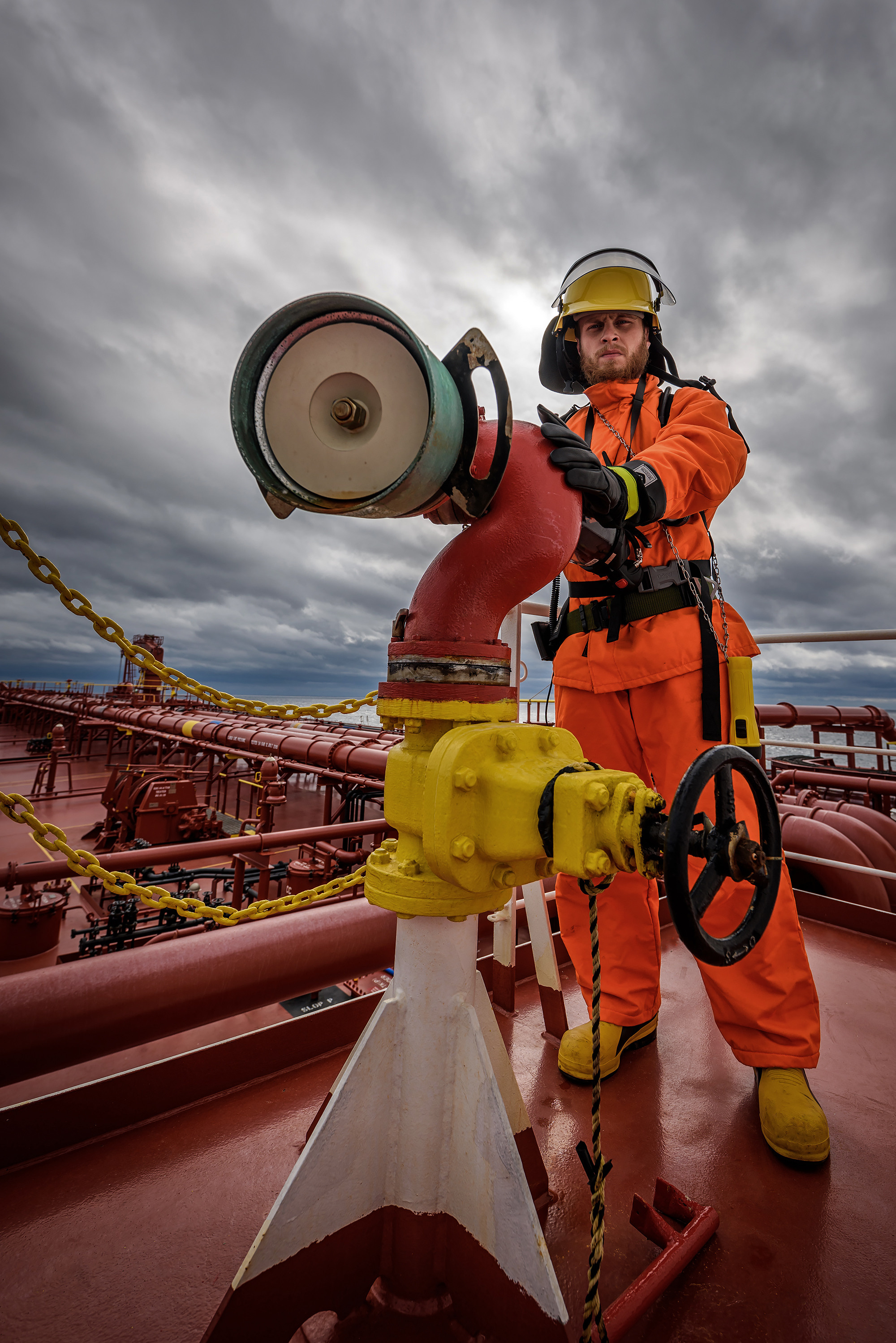 Пожарный в экипировке за пенным монитором