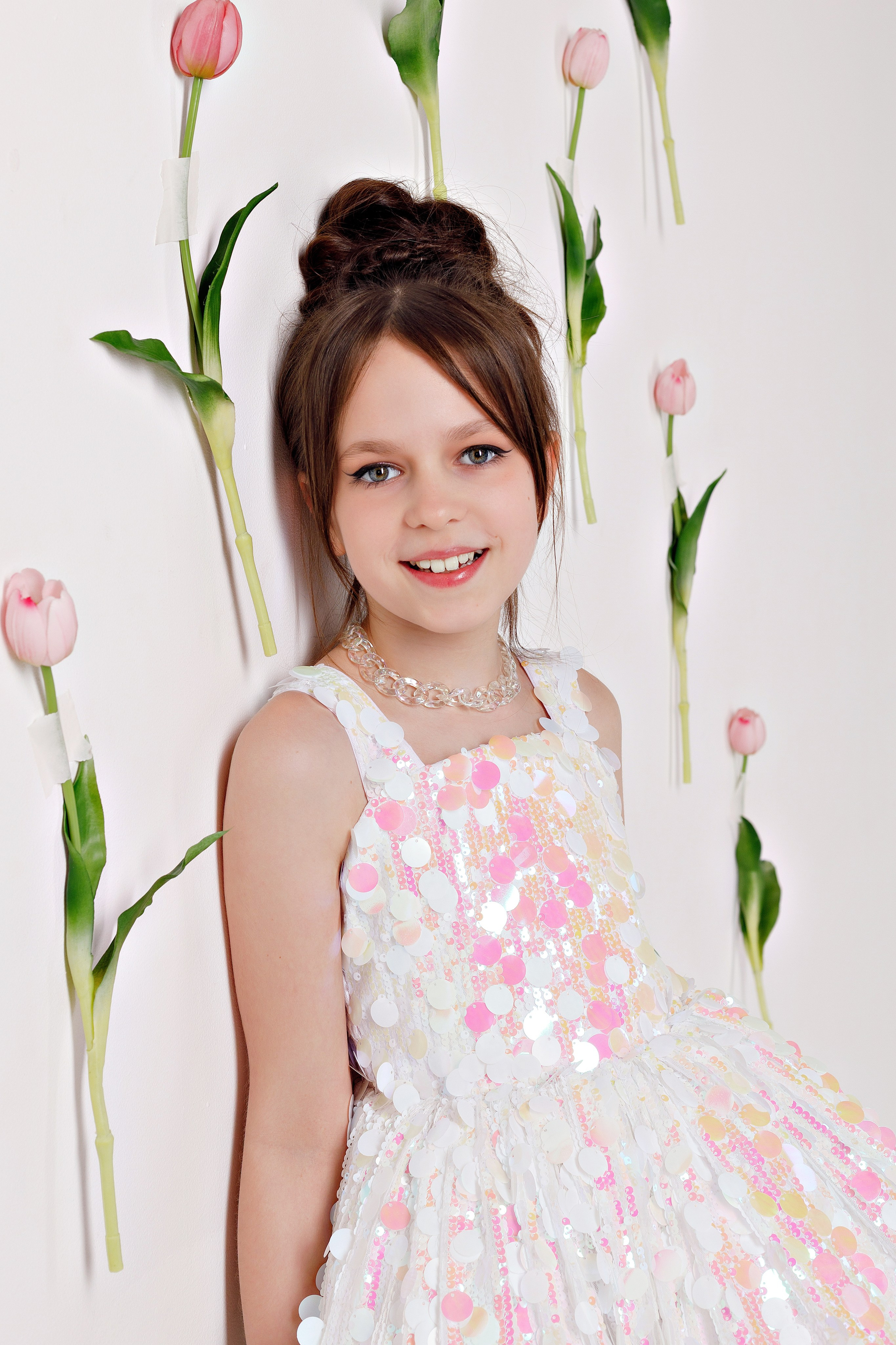 Девочка в праздничном образе с тюльпанами на фоне декораций в Сочи