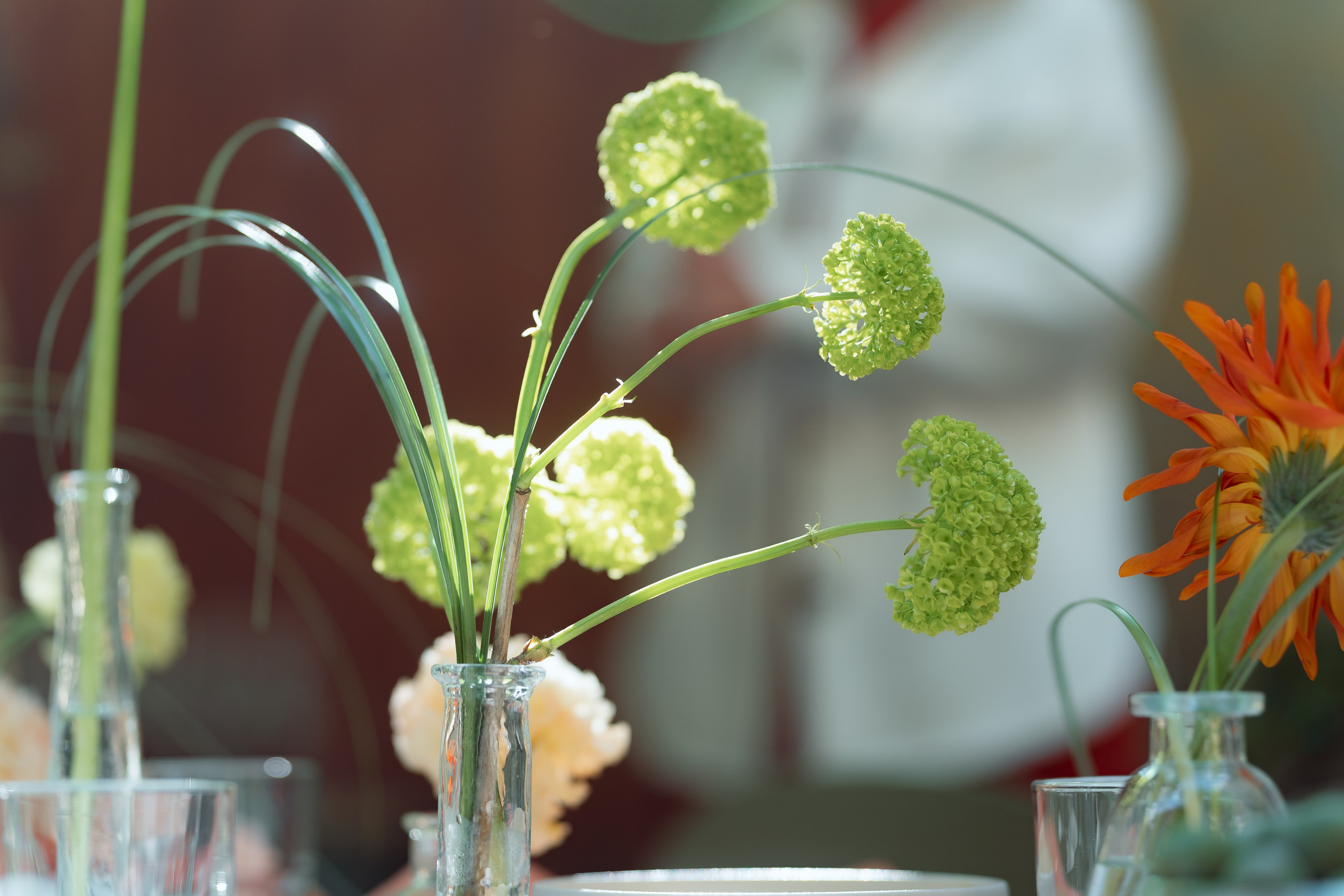 Мини-букет вибурнума и георгины в стеклянных колбах на столе