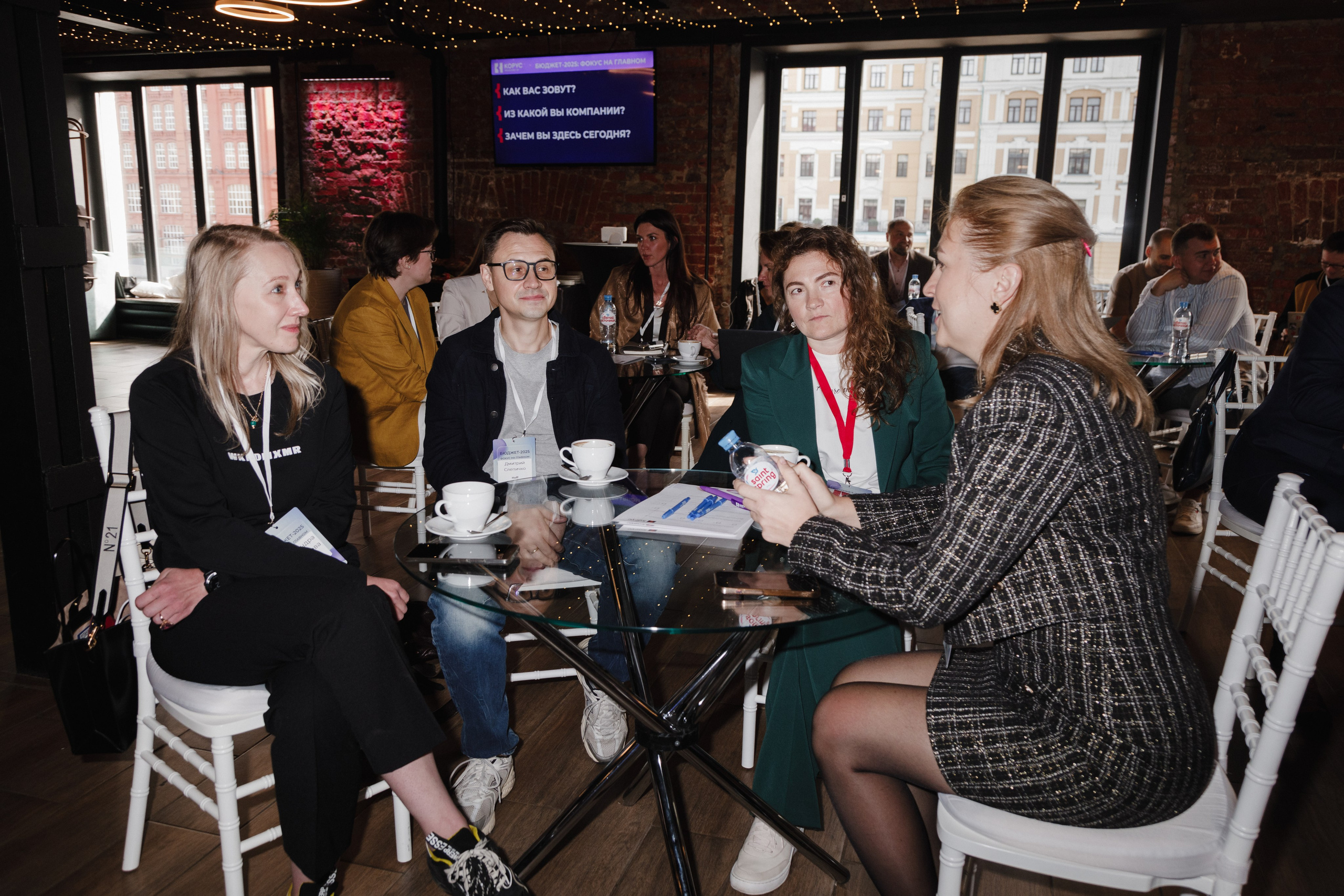 Рабочая атмосфера: общий план зала, где гости за столами слушают выступления.