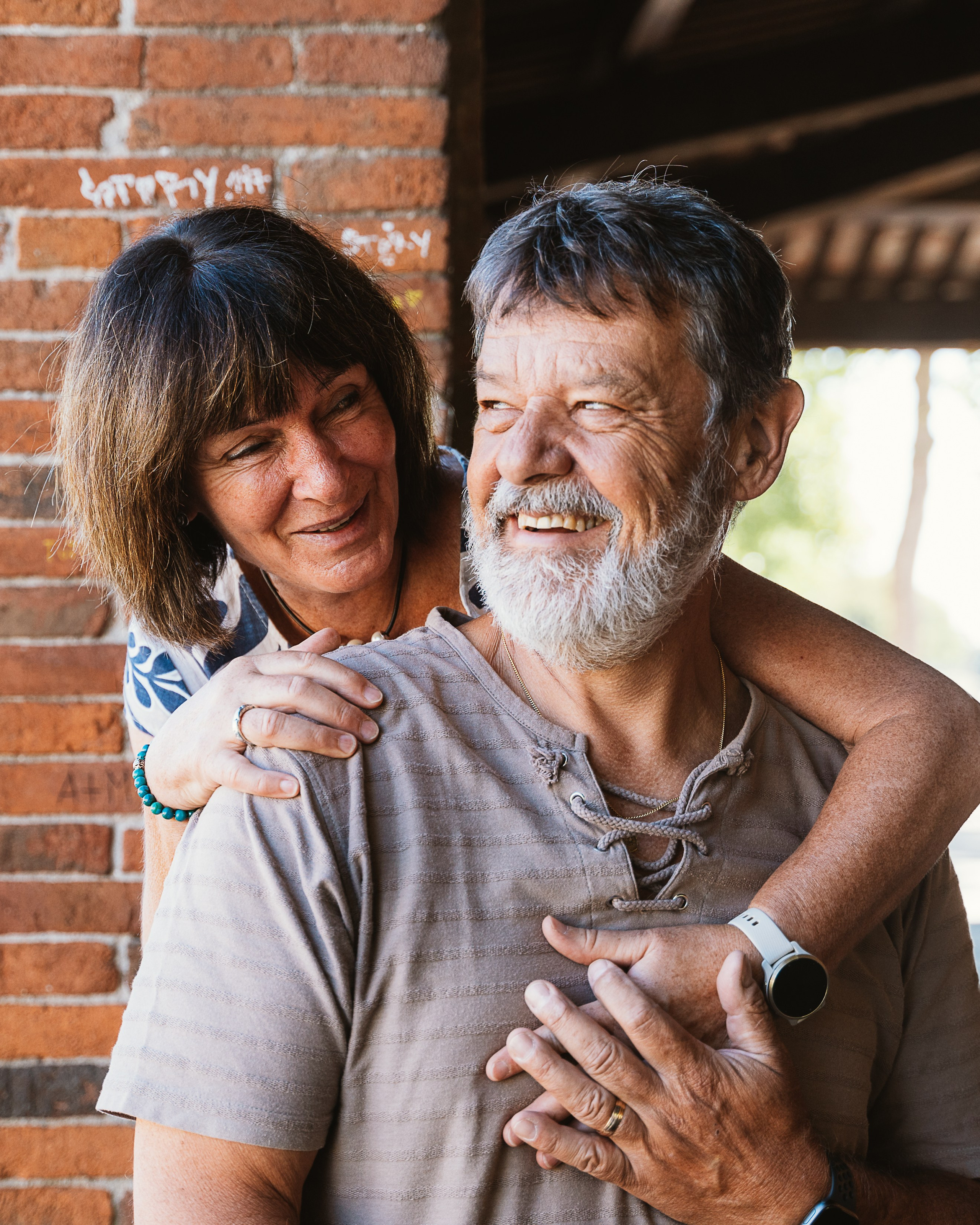 A close-up of the family's loving embrace with Walls of Lucca behind them