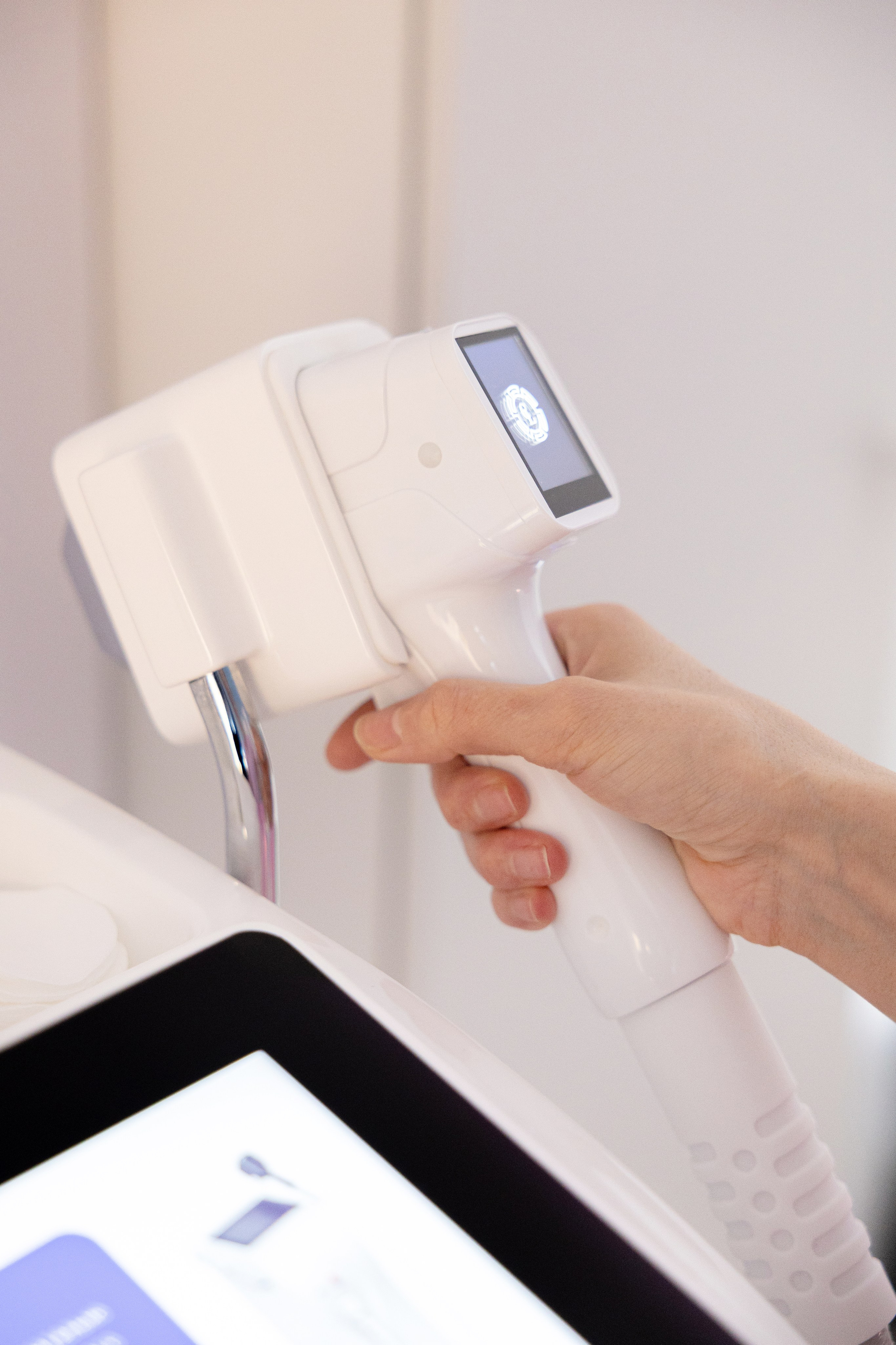 Рука держит ручку прибора для лазерной эпиляции