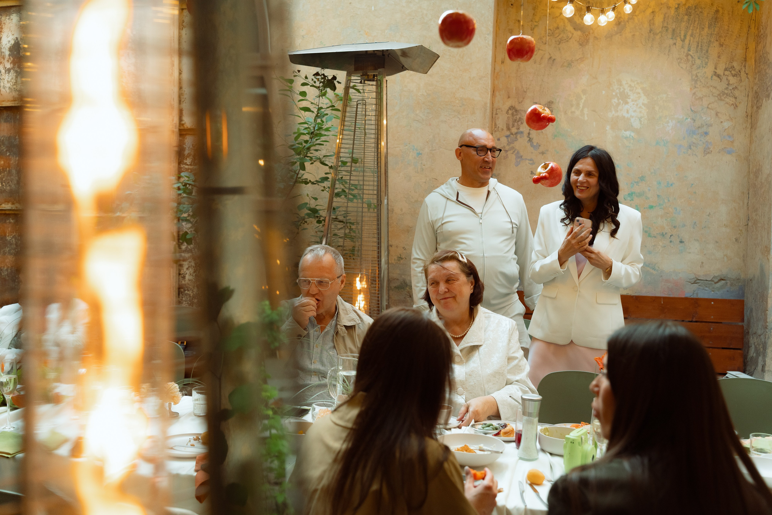 Гостья с тёмными волосами поднимает бокал во время тоста