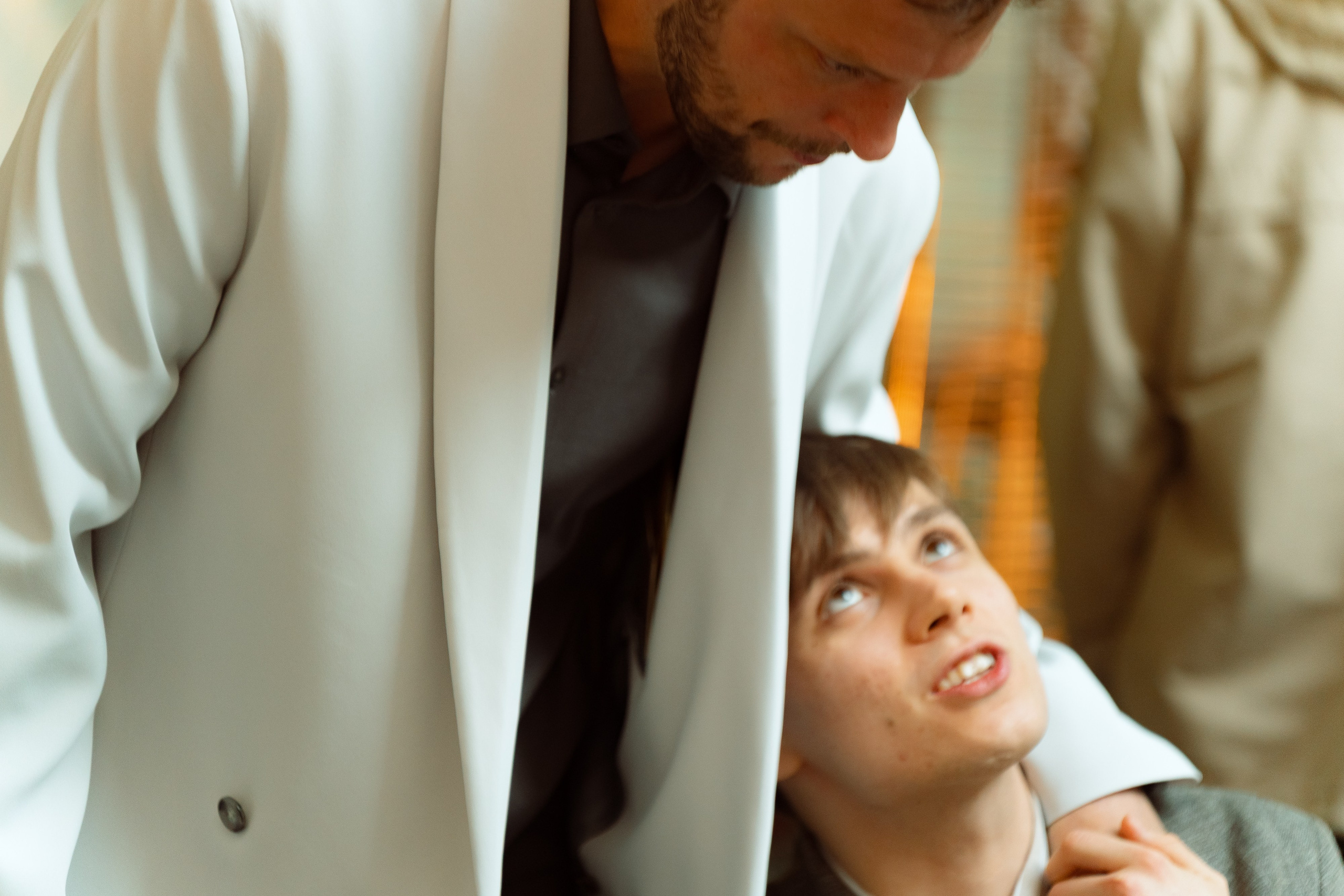 Евгений наклоняется поговорить с братом у столика