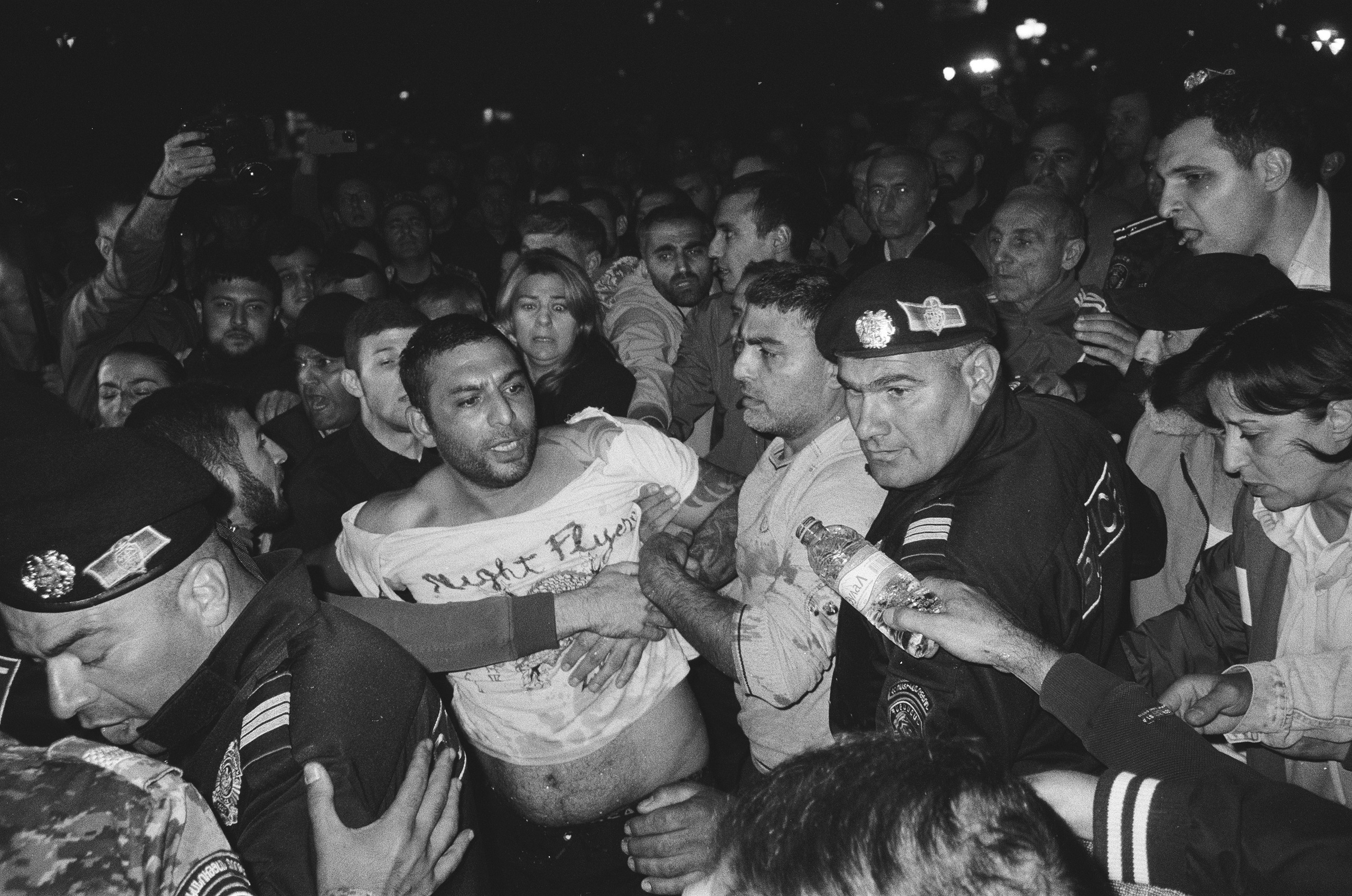 People are holding one of the protesters to prevent the police from apprehending him