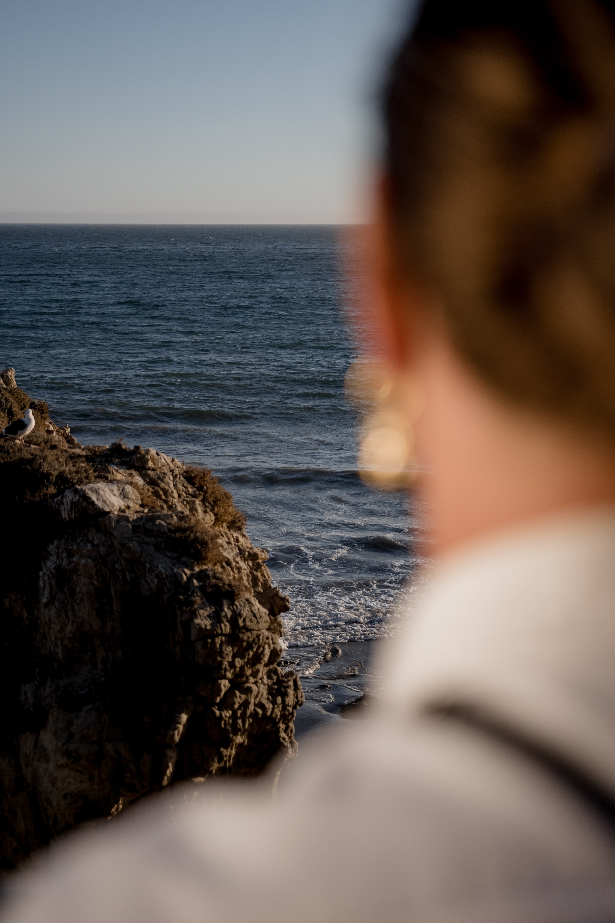 Model gazing at the ocean during a golden hour, blending natural beauty and serenity.