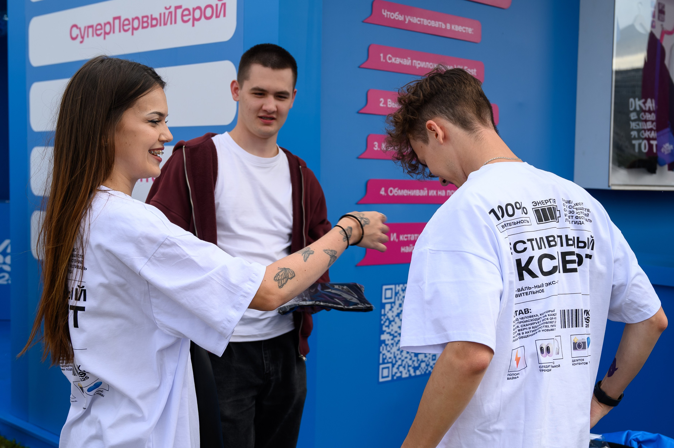 Участники фестиваля VK Fest 2025 в Казани собираются у витрины квеста, момент репортажной съёмки в уличных условиях