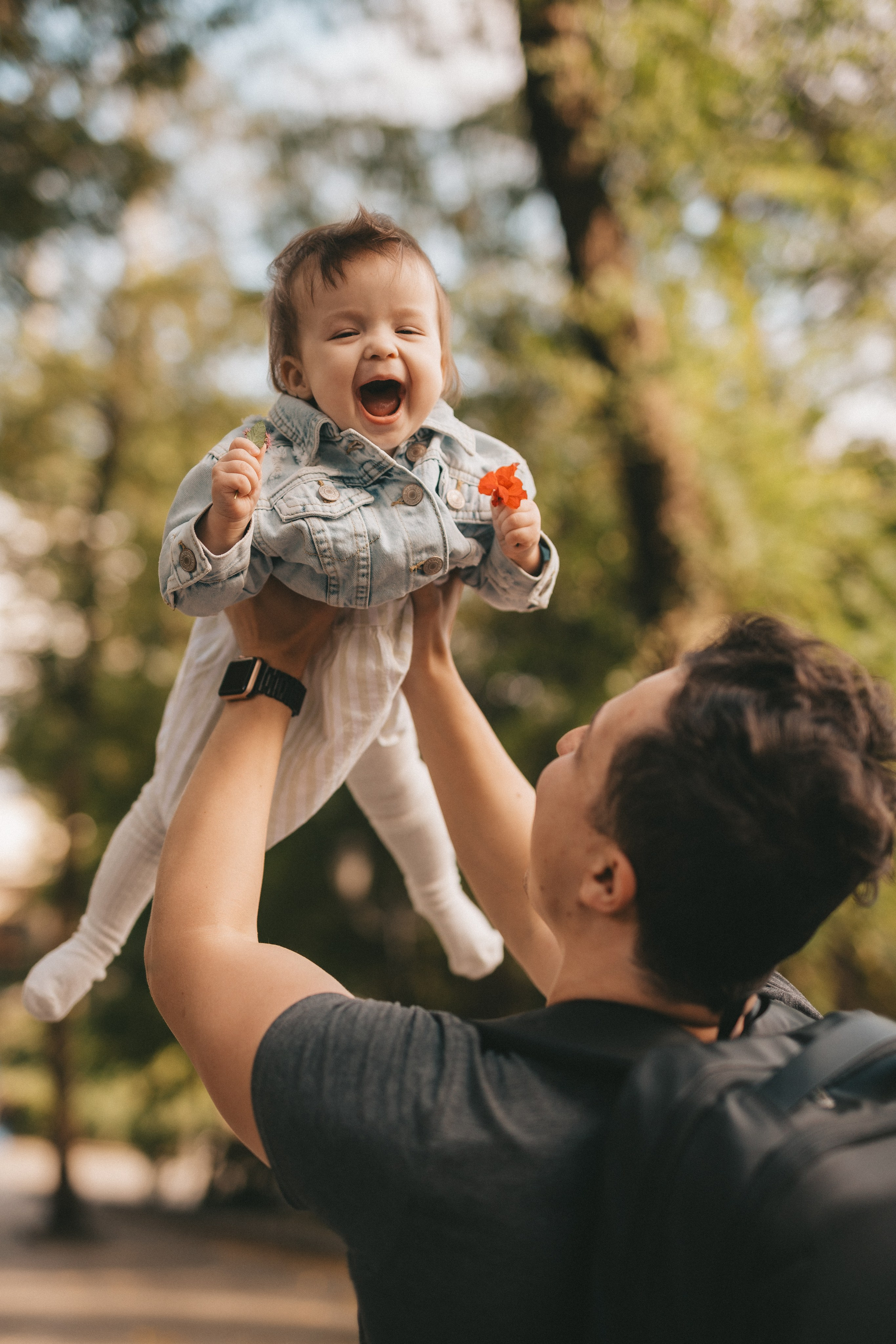 Дочка у папы на руках смеется на фотосессии