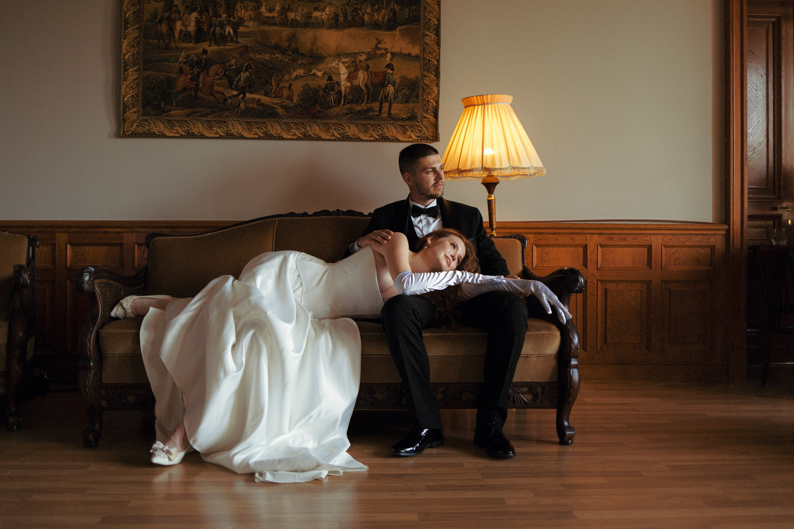 Жених сидит в кресле, невеста рядом — камерная свадебная съёмка в Петербурге