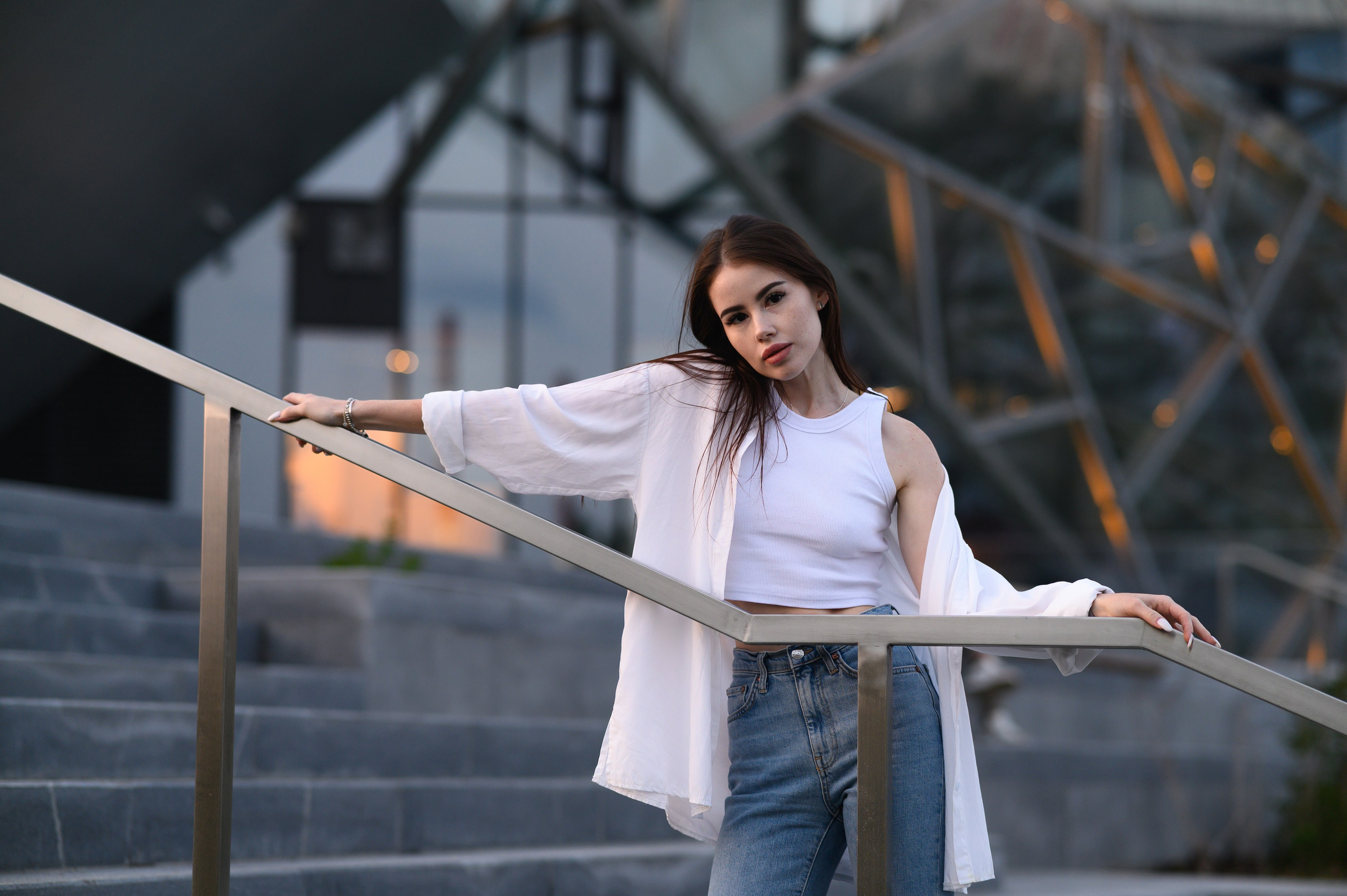 Портретная фотосессия девушки на фоне фасада нового Театра Камала в Казани в мягком закатном свете