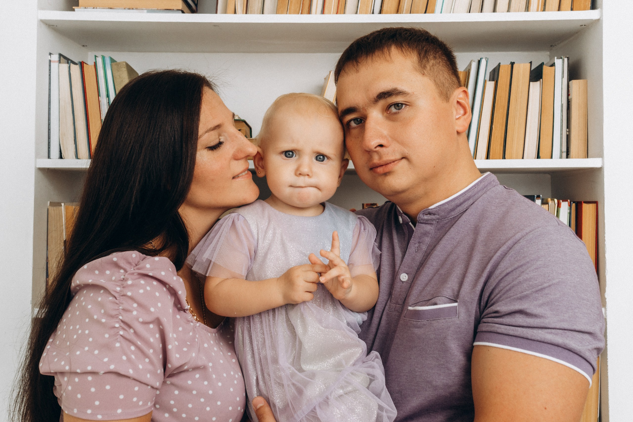 Мама и папа с маленькой Мией в библиотеке профессиональная фотосъемка первого дня рождения