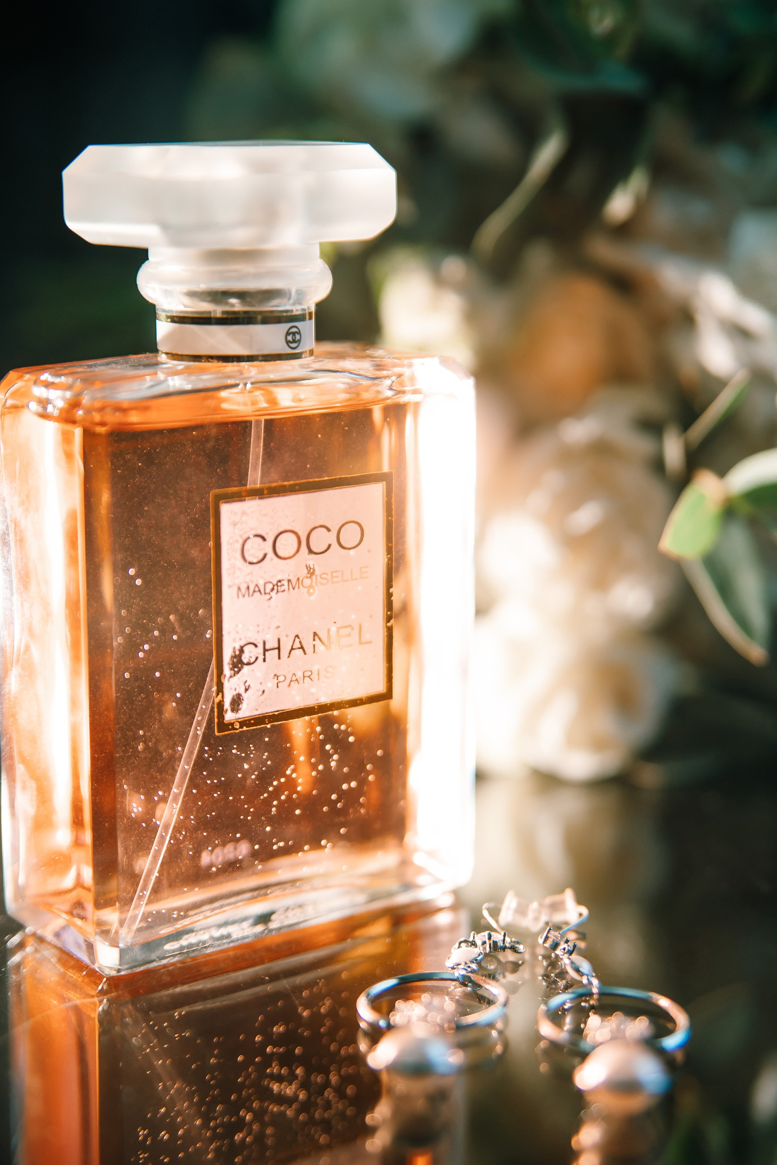 Флакончик духов Coco Chanel рядом с букетом невесты
