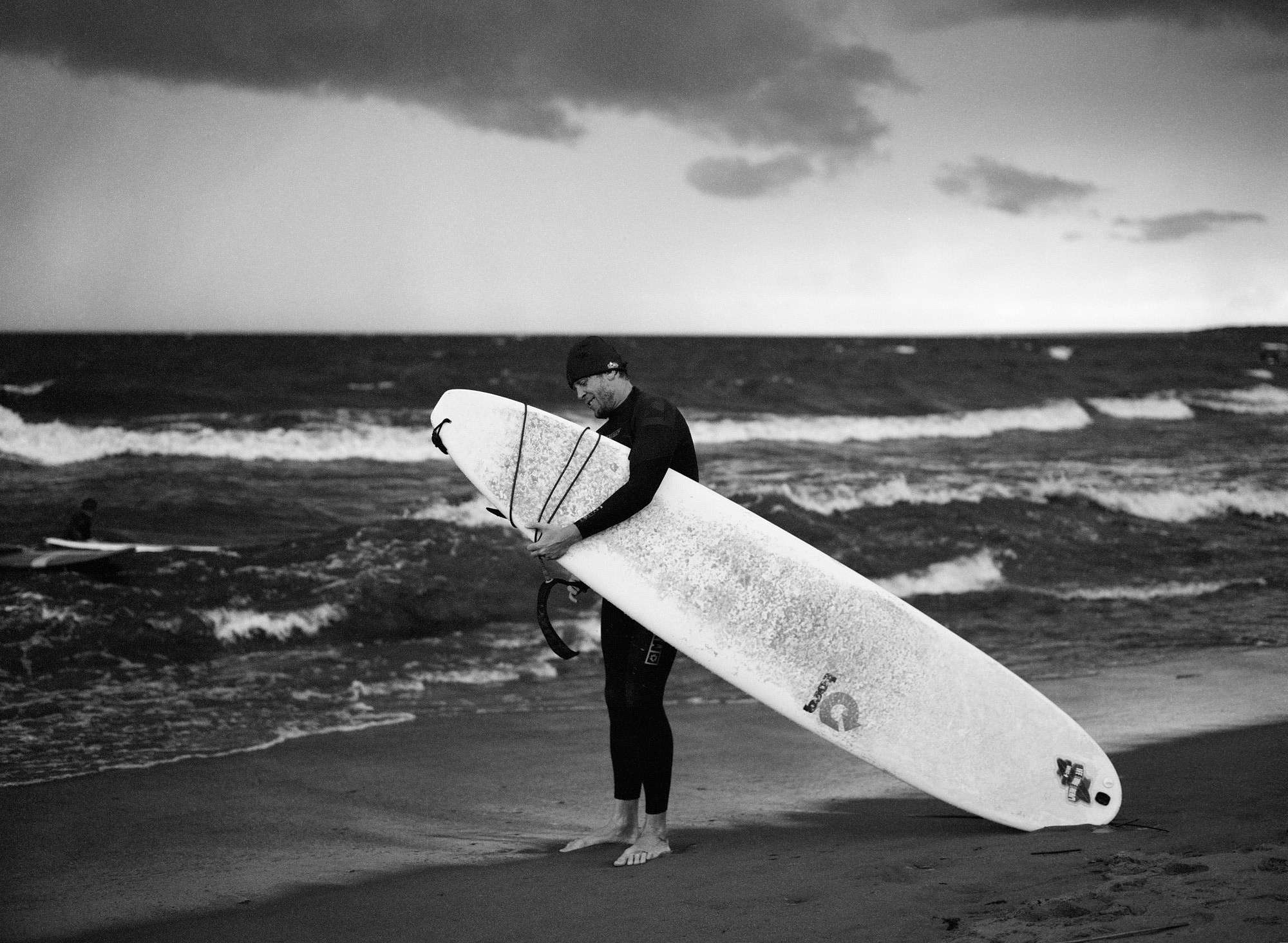 Съёмка на плёнку: сёрфер с доской на фоне бушующего моря