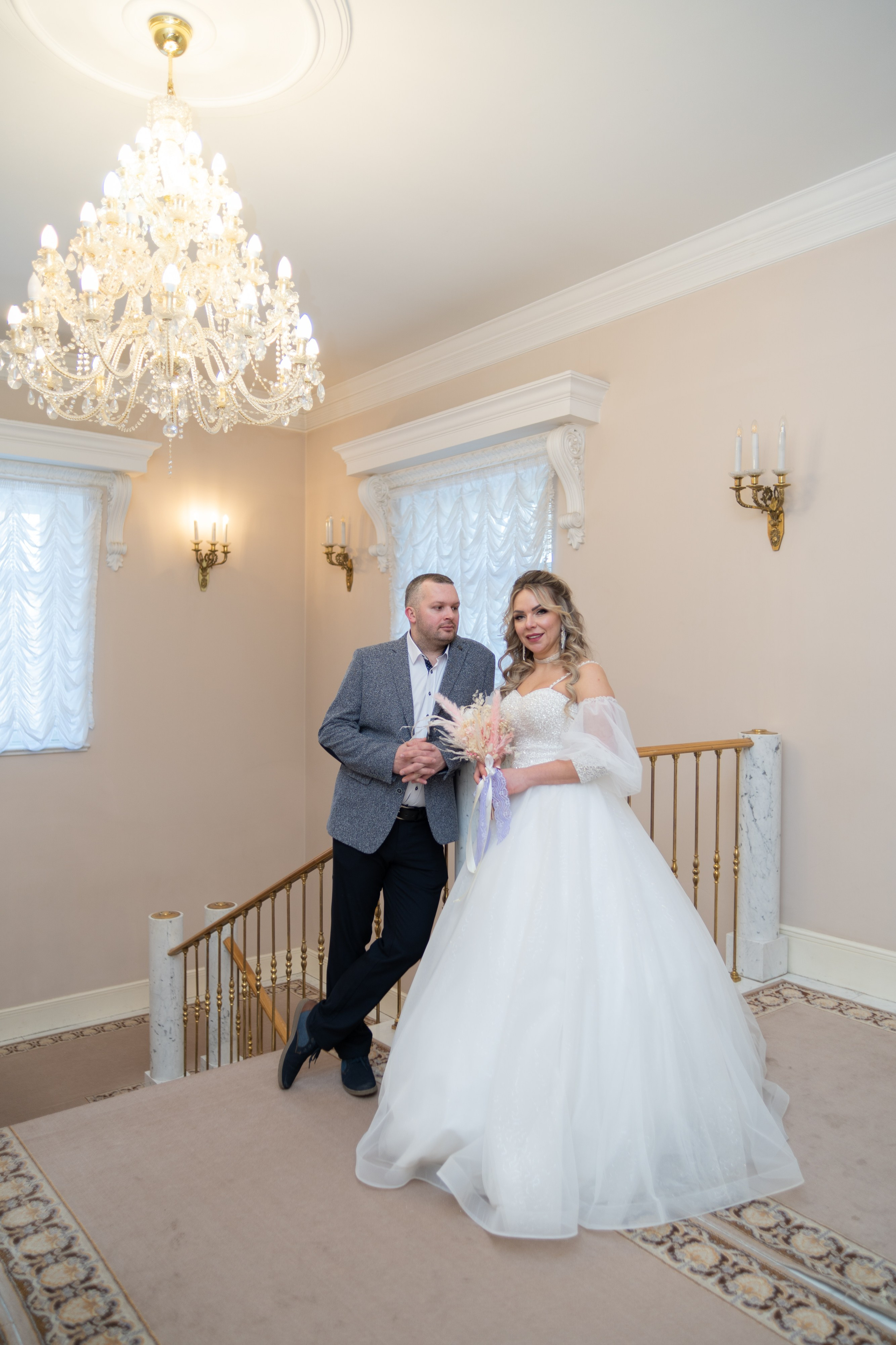 жених и невеста позируют на лестнице дворца бракосочетания 3 в пушкине