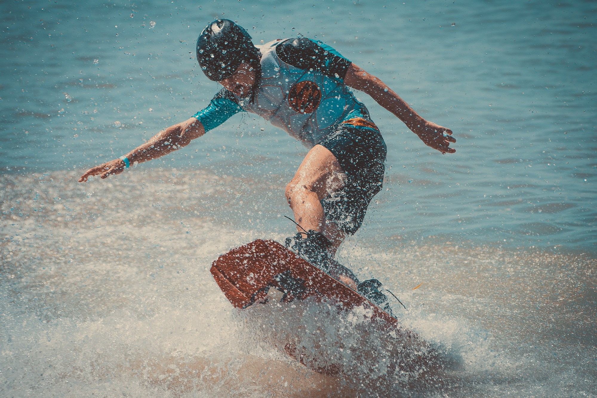 Спортсмен на вейкборде в облаке брызг