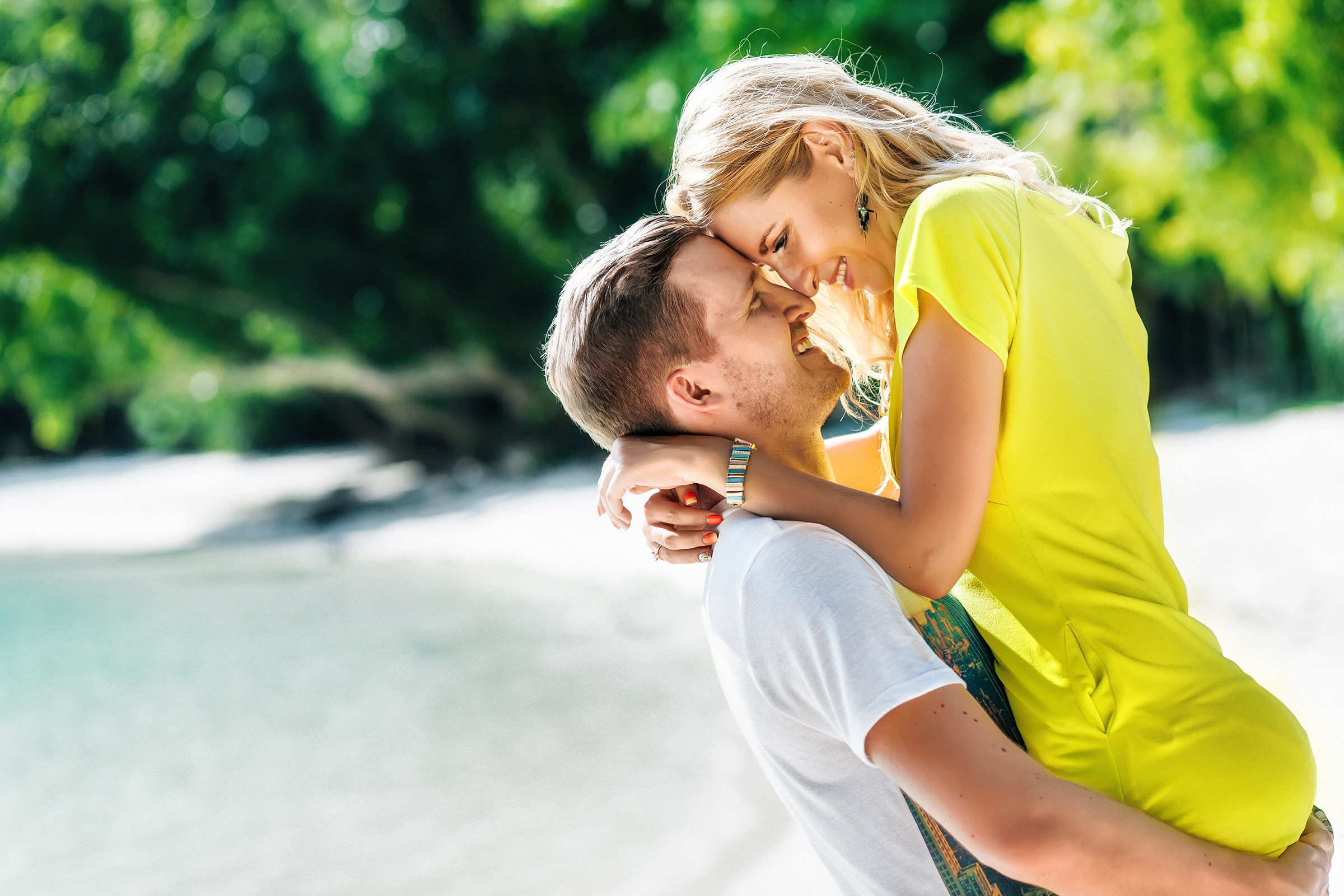 парень поднимает девушку на берегу острова