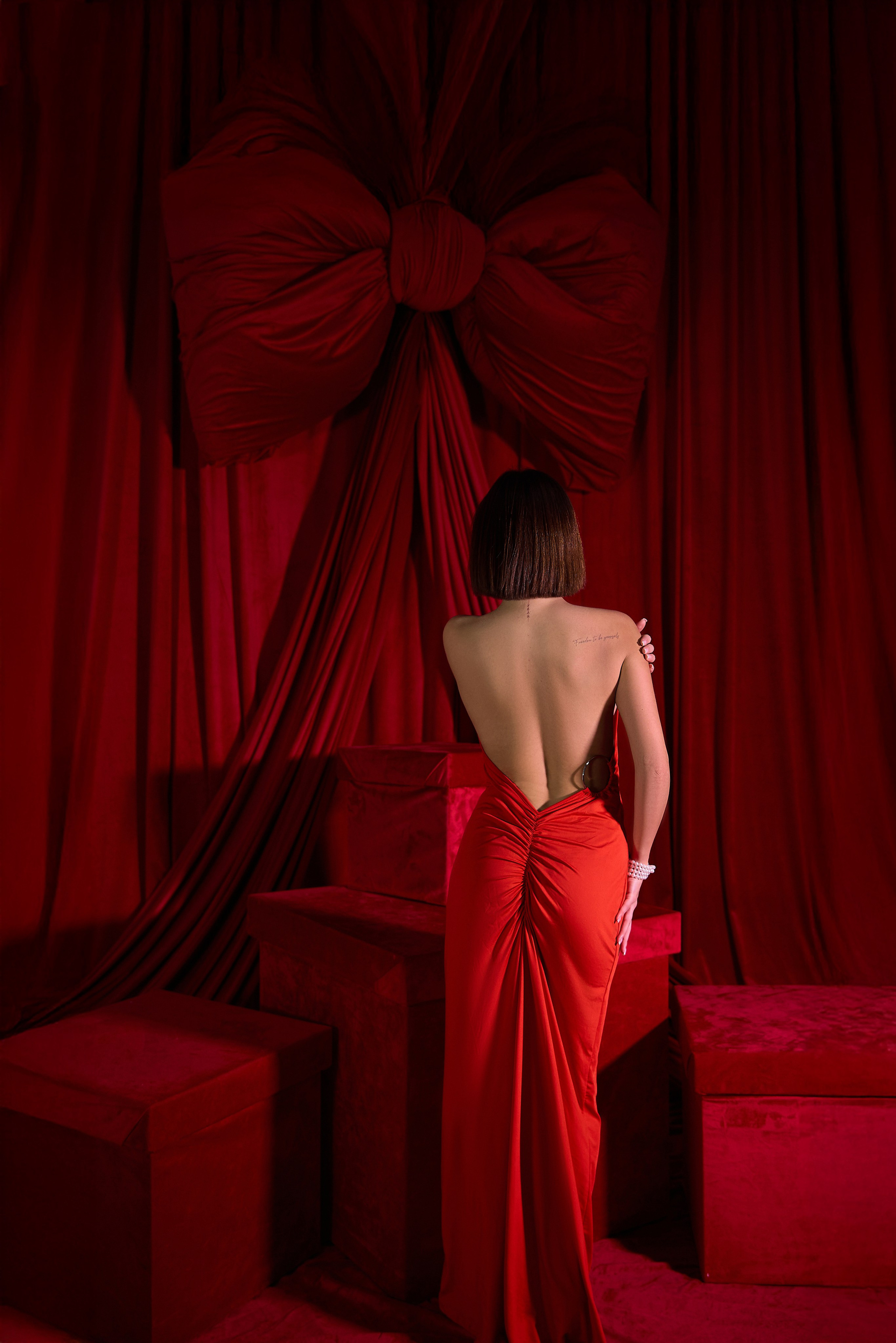 Девушка в красном на красном фоне со спины
